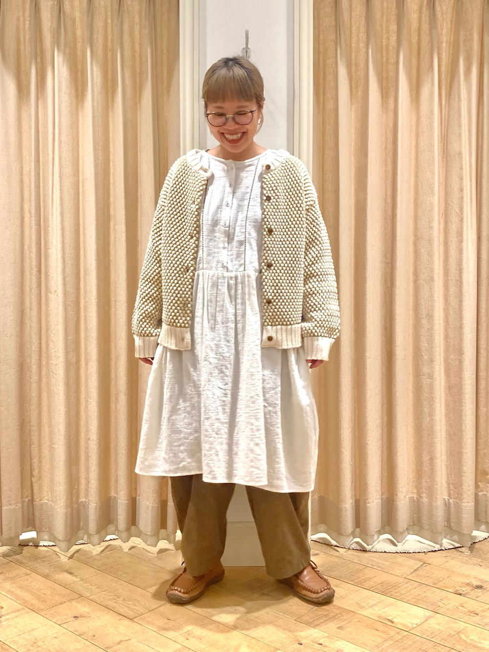 ホワイト系のチュニック、イエロー系のカーディガン/ボレロ、グリーン系のその他パンツを着用したレディースの冬コーディネートの2枚目の写真