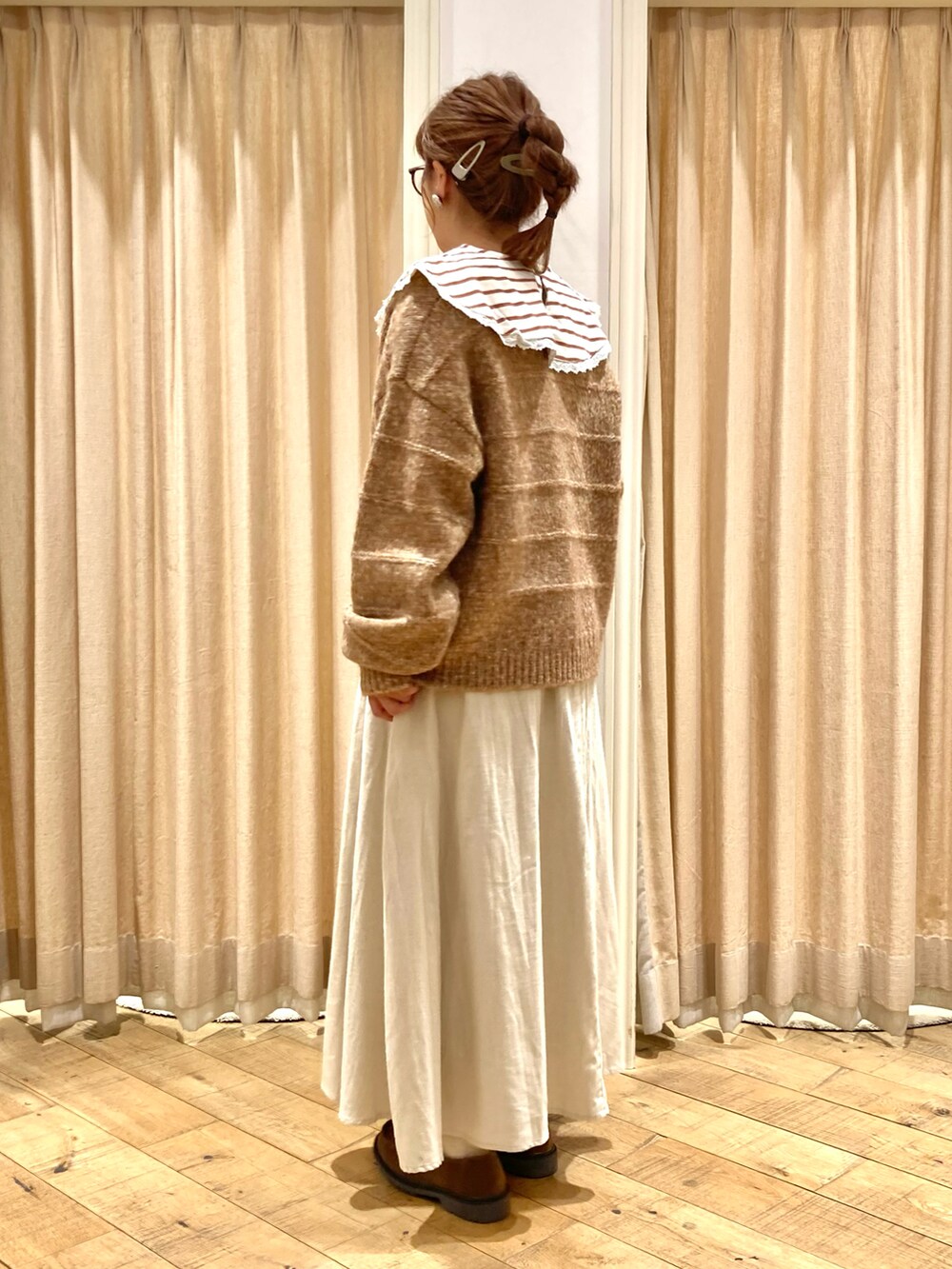 オレンジ系のカーディガン/ボレロ、ベージュ系のスカート、ベージュ系のTシャツ/カットソーを着用したレディースの秋コーディネートの2枚目の写真