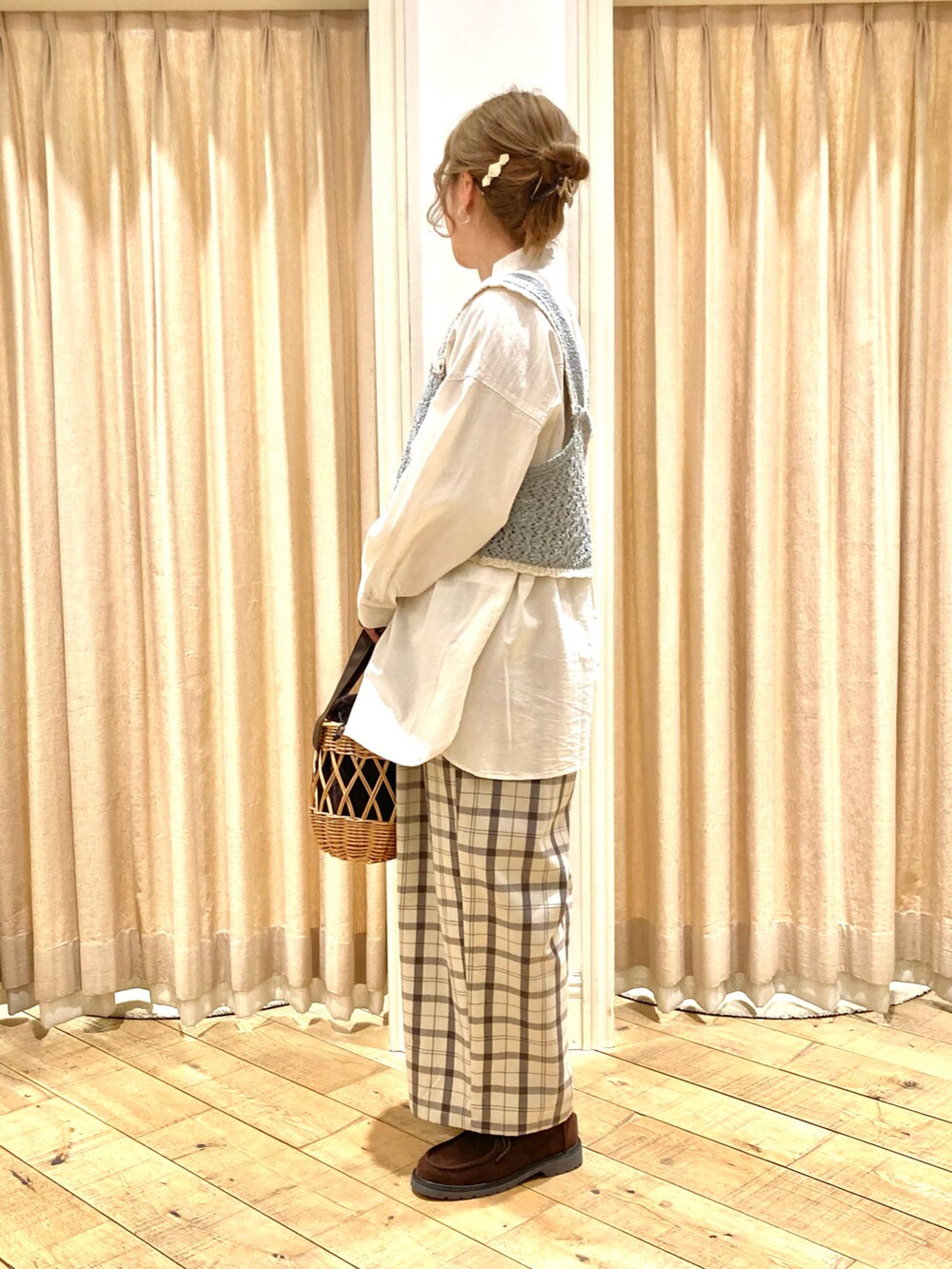 ホワイト系のチュニック、ブルー系のベスト、ベージュ系のその他パンツを着用したレディースの冬コーディネートの2枚目の写真