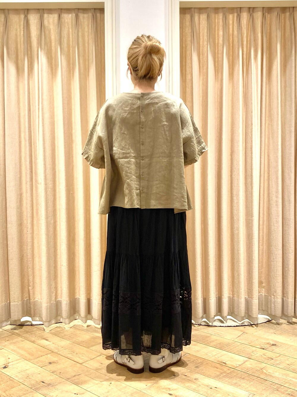 イエロー系のシャツ/ブラウス、ブラック系のスカート、ホワイト系のサンダルを着用したレディースの夏コーディネートの4枚目の写真