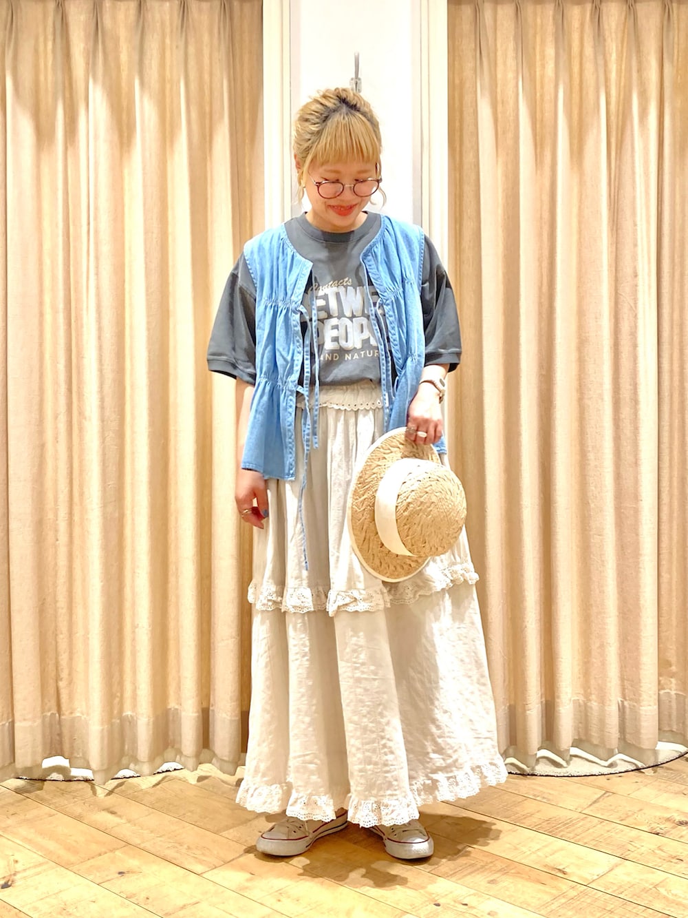 グレー系のTシャツ/カットソー、ブルー系のベスト、ベージュ系のスカートを着用したレディースの夏コーディネートの2枚目の写真