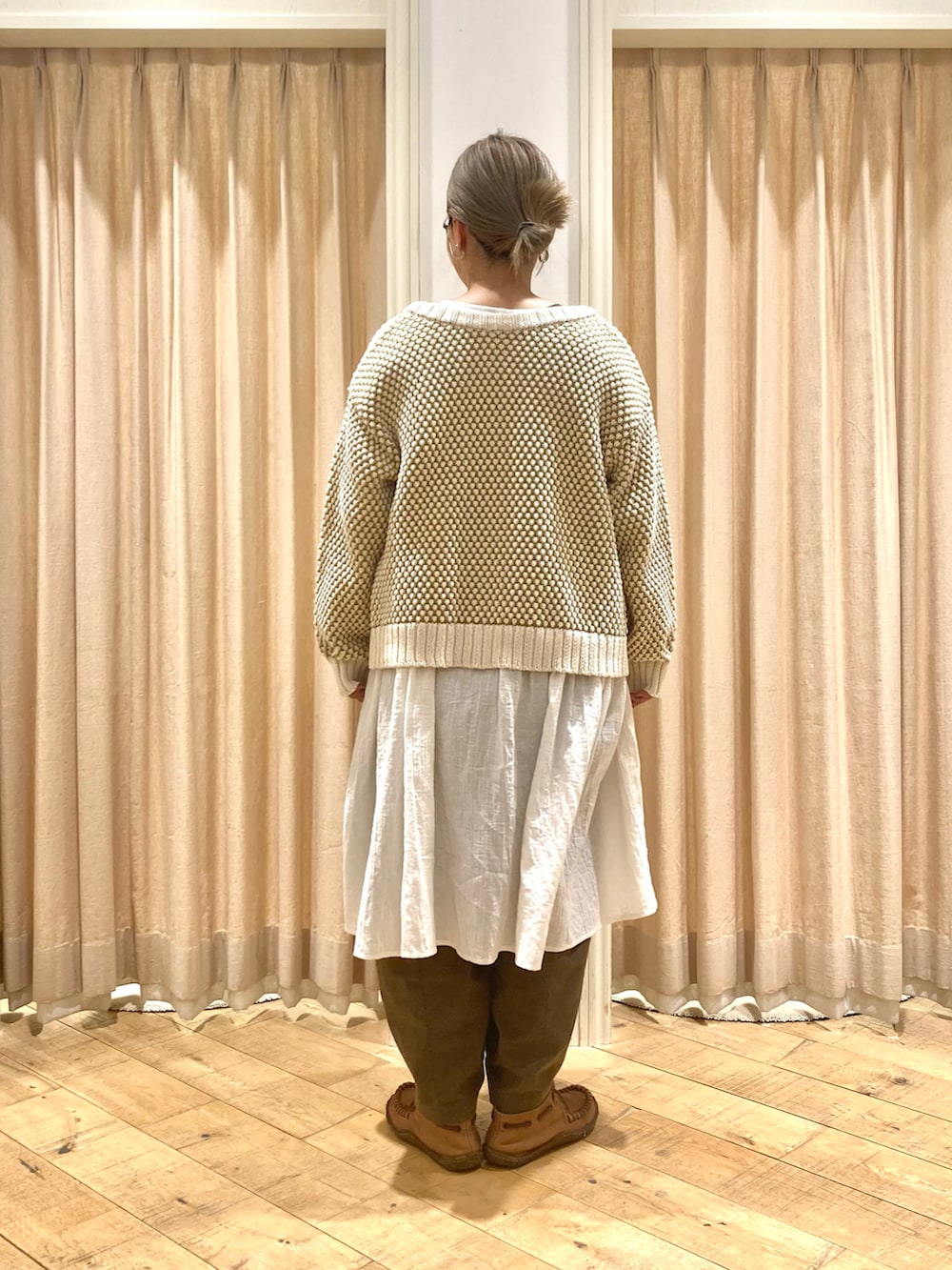 ホワイト系のチュニック、イエロー系のカーディガン/ボレロ、グリーン系のその他パンツを着用したレディースの冬コーディネートの4枚目の写真