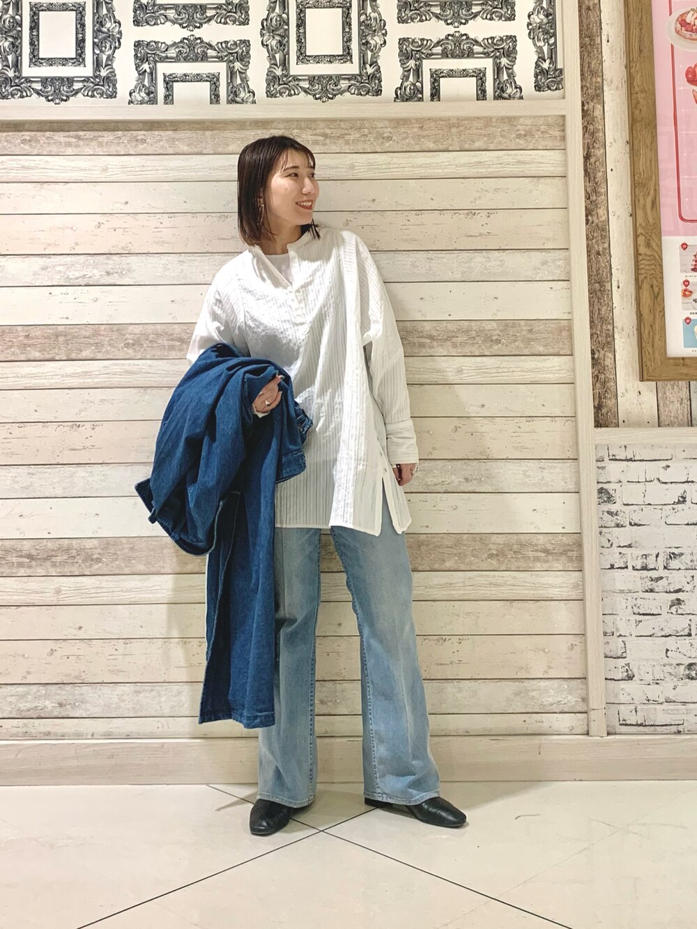 ホワイト系のシャツ/ブラウス、ブルー系のステンカラーコート、ブルー系のデニムパンツを着用したレディースの冬コーディネートの3枚目の写真