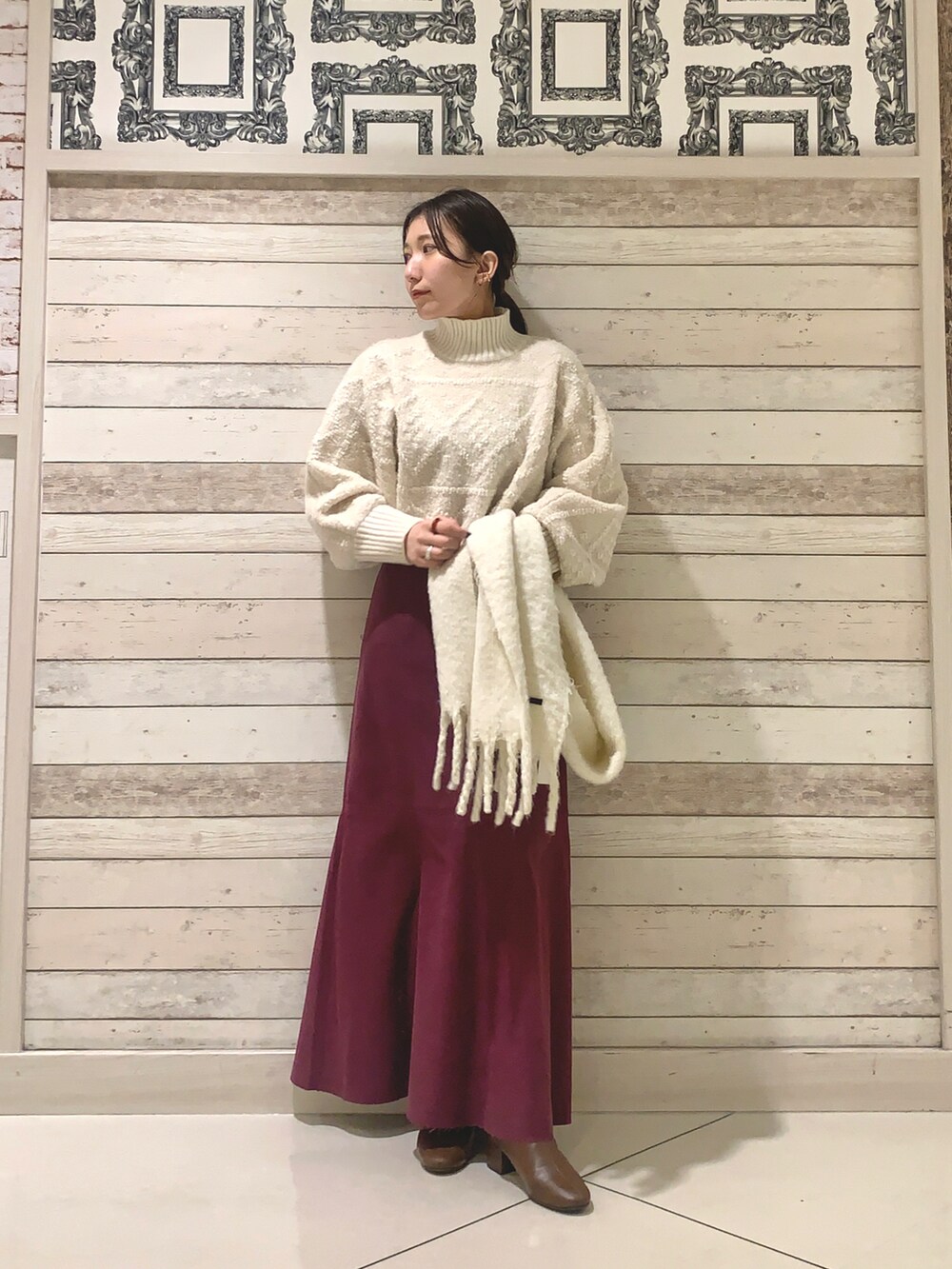 ホワイト系のニット/セーター、イエロー系のブーツを着用したレディースの冬コーディネートの2枚目の写真