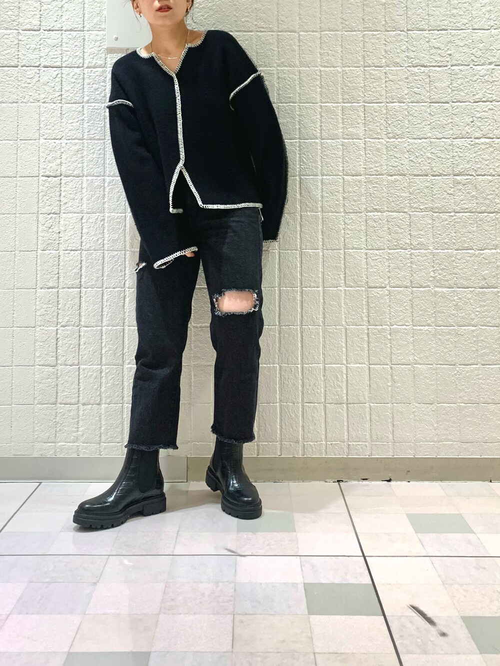 ブラック系のニット/セーター、ブラック系のデニムパンツを着用したレディースの冬コーディネートの2枚目の写真