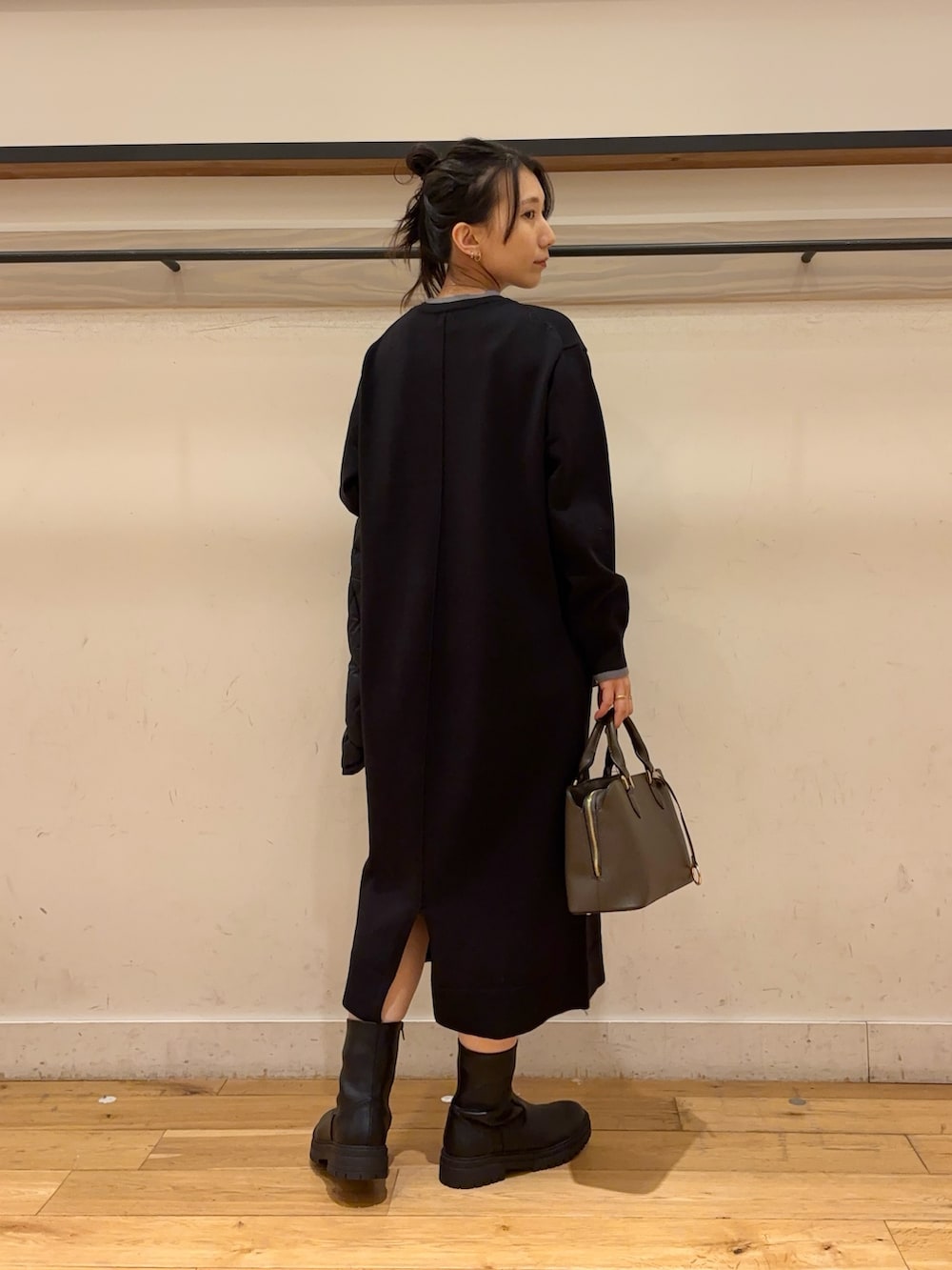 ブラウン系のブーツ、ブラック系のワンピース、ブルー系のダウンジャケット/コートを着用したレディースの冬コーディネートの2枚目の写真