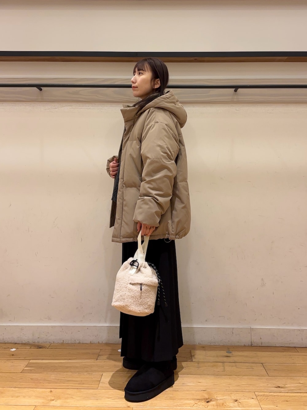 ブラウン系のダウンジャケット/コート、ブラック系のスカート、ブラック系のブーツを着用したレディースの冬コーディネートの2枚目の写真