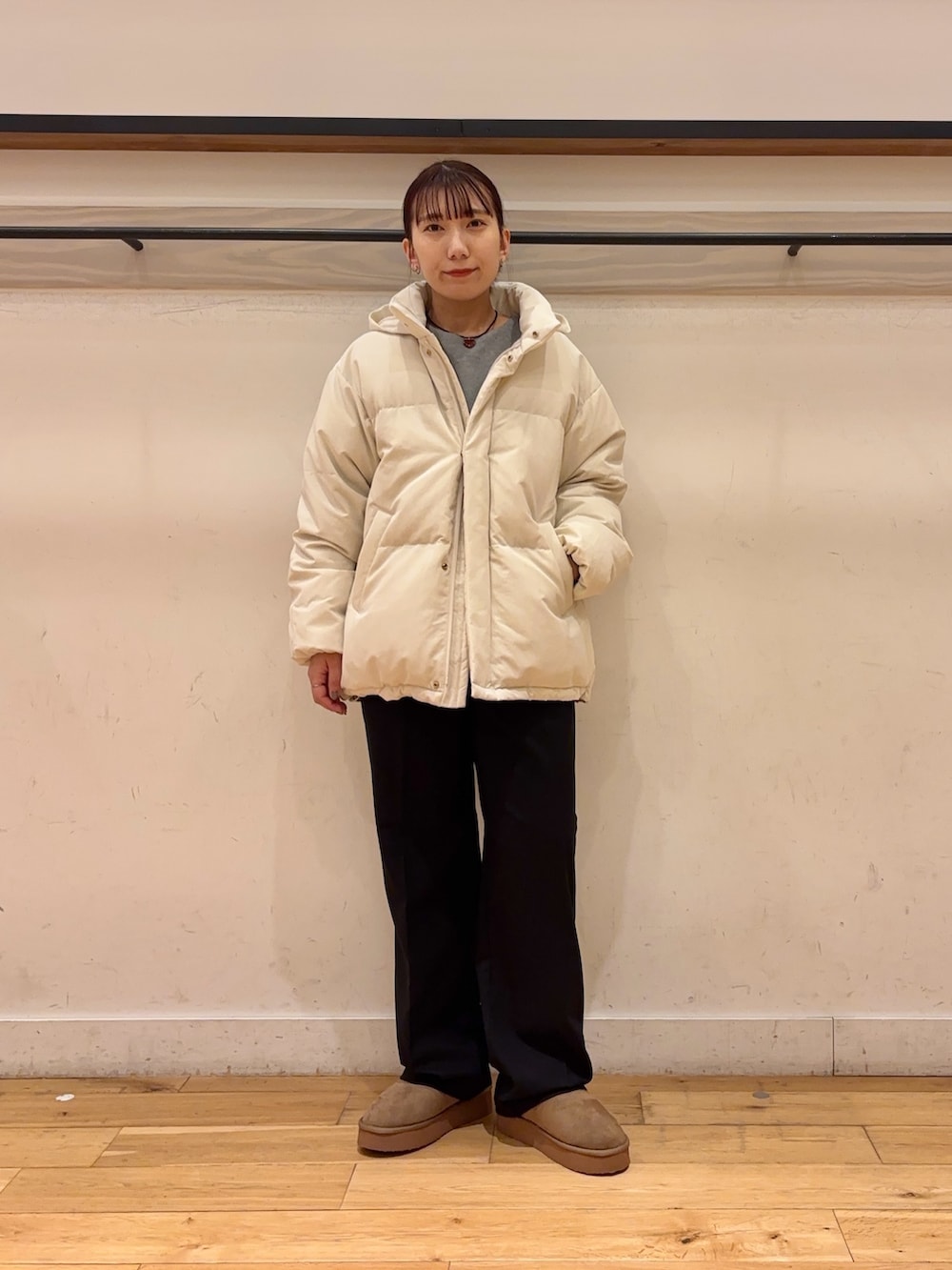 ホワイト系のダウンジャケット/コート、グレー系のニット/セーター、ブラック系のその他パンツを着用したレディースの冬コーディネートの2枚目の写真