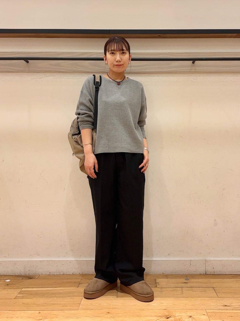 ホワイト系のダウンジャケット/コート、グレー系のニット/セーター、ブラック系のその他パンツを着用したレディースの冬コーディネートの6枚目の写真