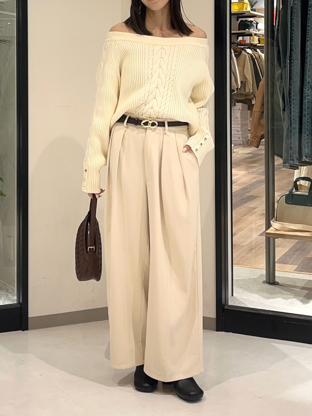 ホワイト系のニット/セーター、ホワイト系のスラックス、ブラック系のブーツを着用したレディースの冬コーディネートの2枚目の写真