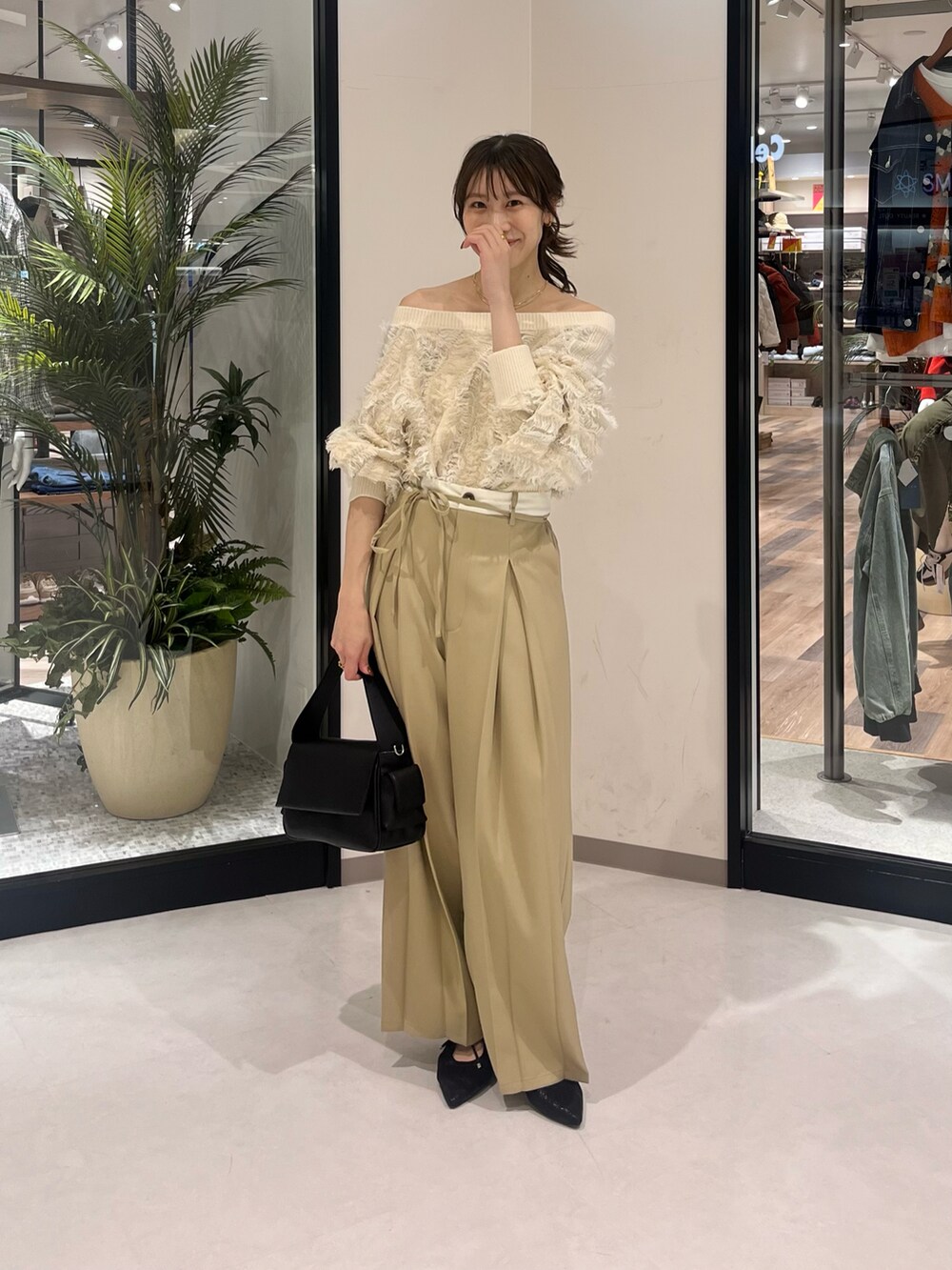 ホワイト系のニット/セーター、ベージュ系のその他パンツ、ブラック系のボストンバッグを着用したレディースの春コーディネートの2枚目の写真