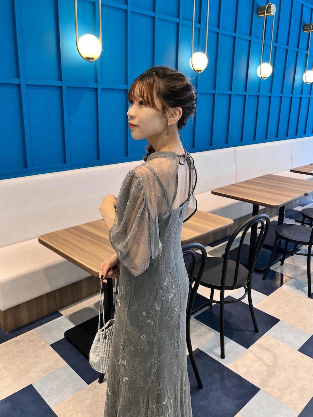 グレー系のドレス、シルバー系のハンドバッグを着用したレディースの秋コーディネートの4枚目の写真