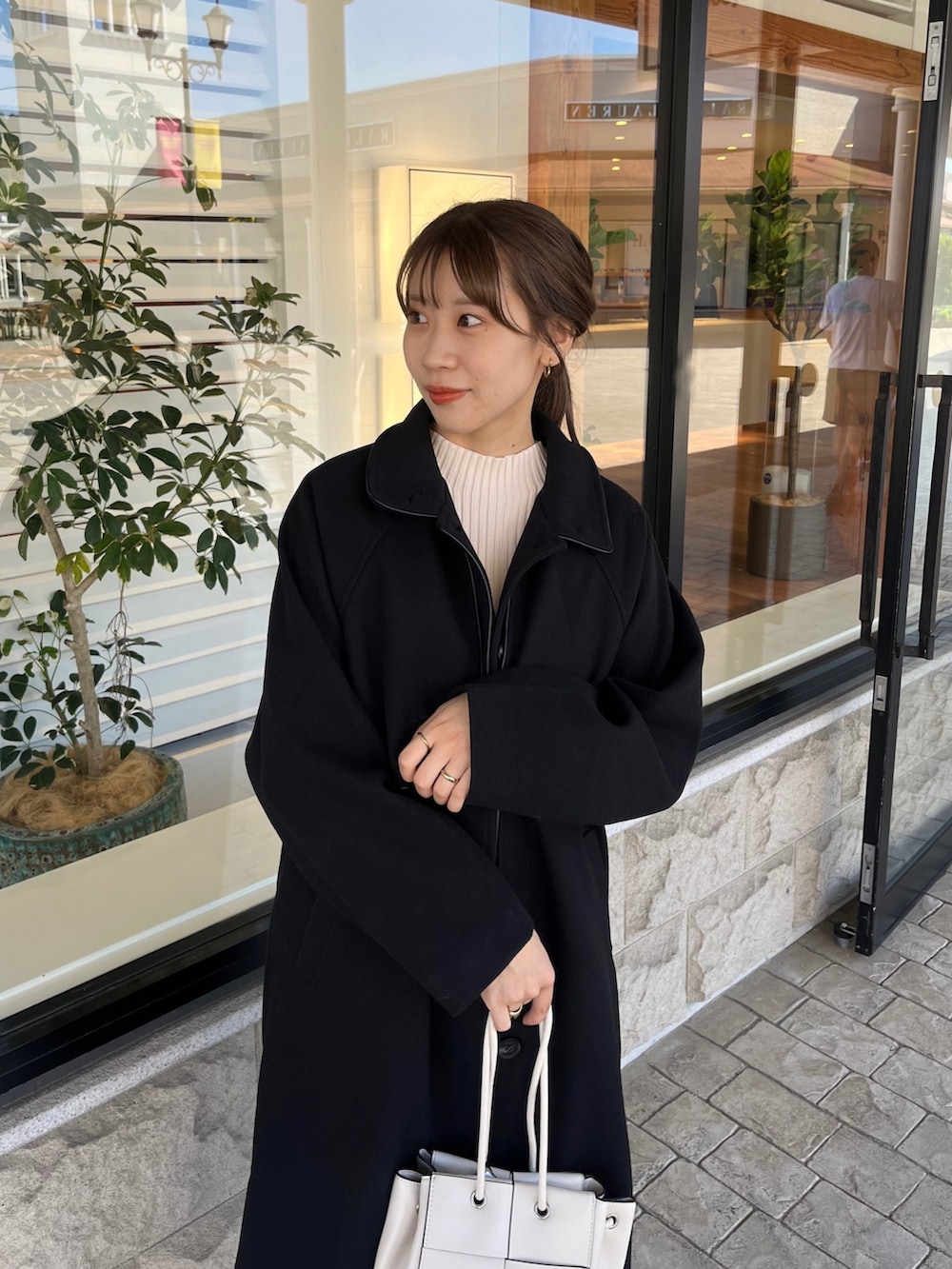 ホワイト系のニット/セーター、ブルー系のデニムパンツ、ホワイト系のショルダーバッグを着用したレディースの秋コーディネートの4枚目の写真