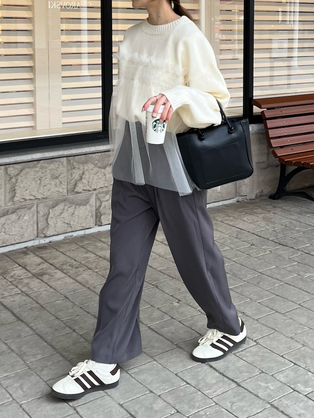 ホワイト系のニット/セーター、グレー系のスラックスを着用したレディースの冬コーディネートの4枚目の写真