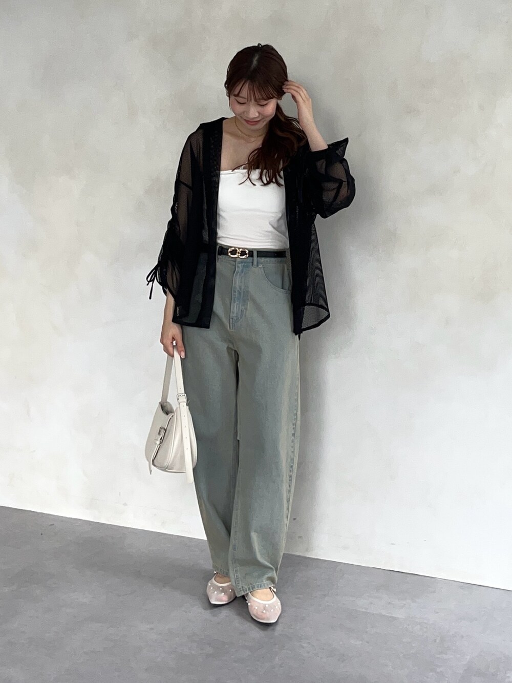 ブラック系のシャツ/ブラウス、ホワイト系のキャミソール、ブルー系のデニムパンツを着用したレディースの春コーディネートの2枚目の写真