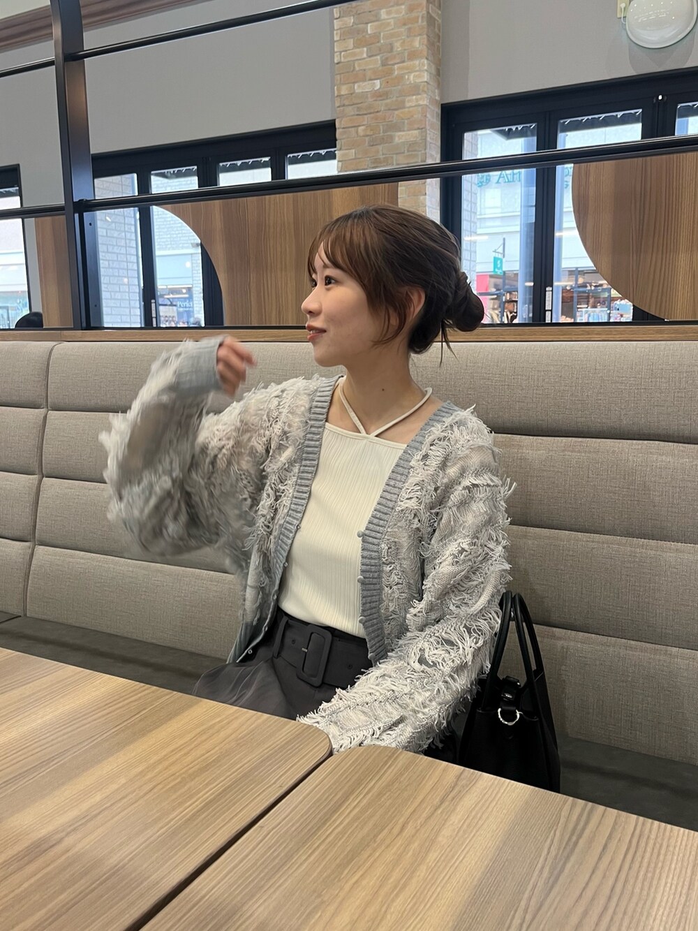 ホワイト系のTシャツ/カットソー、グレー系のカーディガン/ボレロ、グレー系のスラックスを着用したレディースの冬コーディネートの4枚目の写真