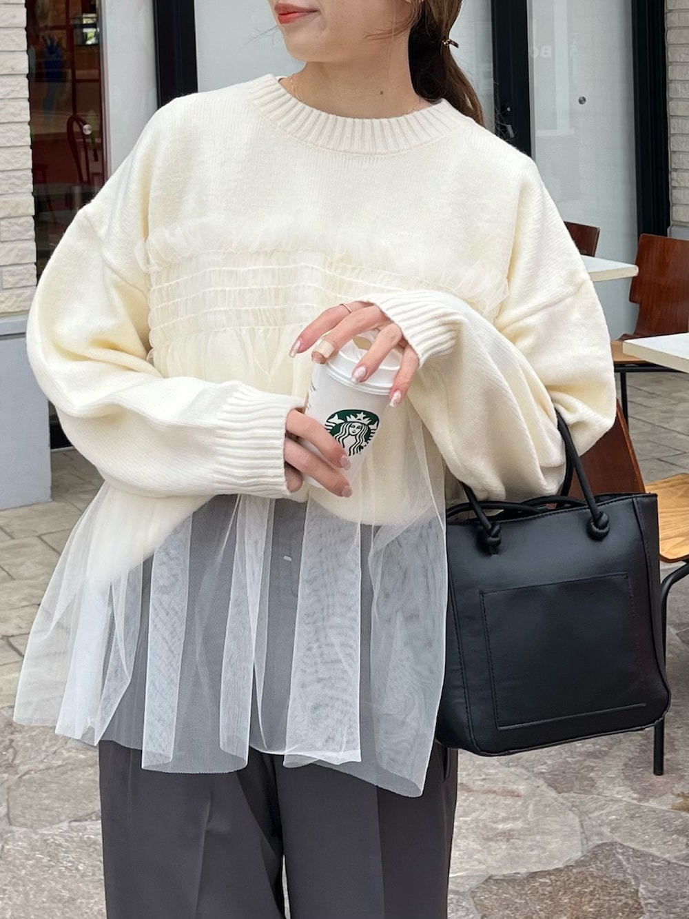 ホワイト系のニット/セーター、グレー系のスラックスを着用したレディースの冬コーディネートの3枚目の写真