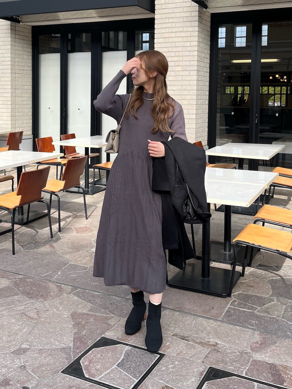 グレー系のワンピース、ブラック系のブーツを着用したレディースの冬コーディネートの3枚目の写真