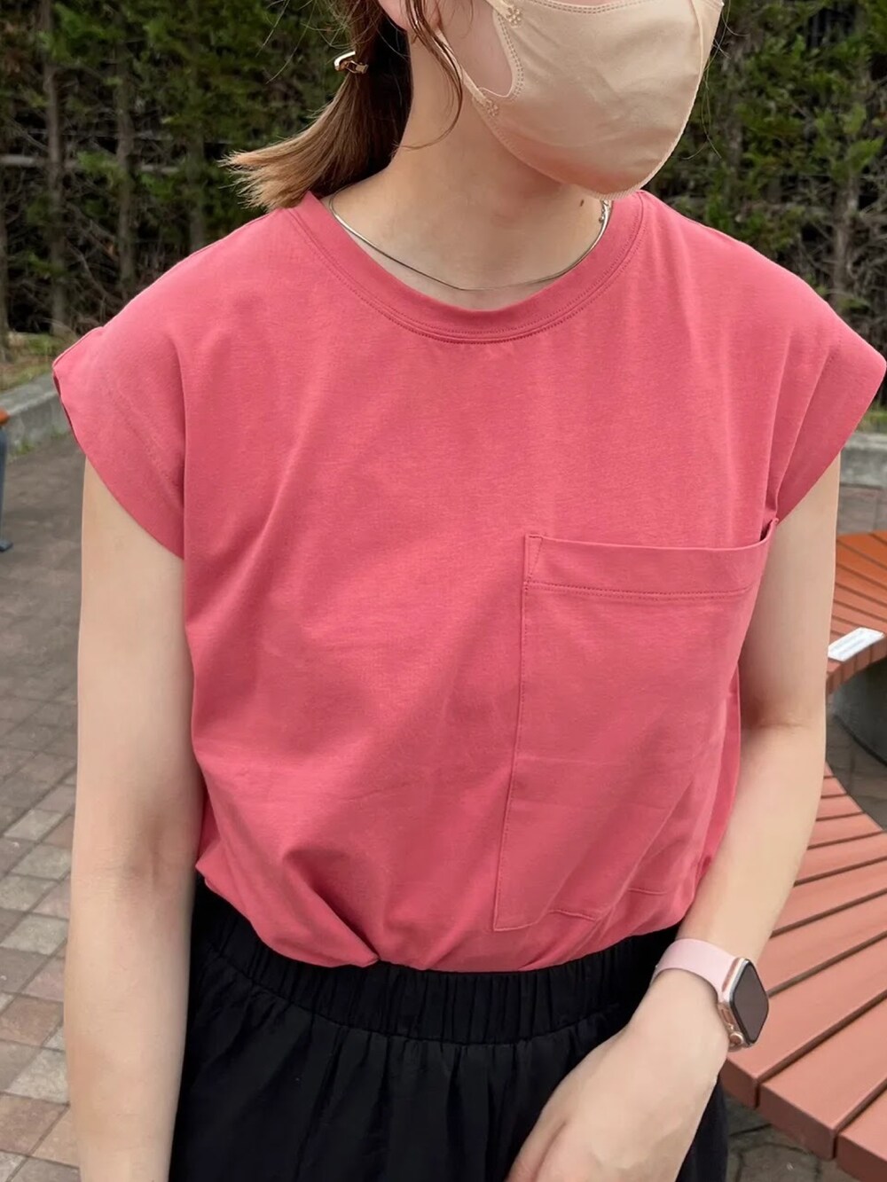 オレンジ系のTシャツ/カットソー、ブラック系のスカート、ブラック系のサンダルを着用したレディースの夏コーディネートの2枚目の写真