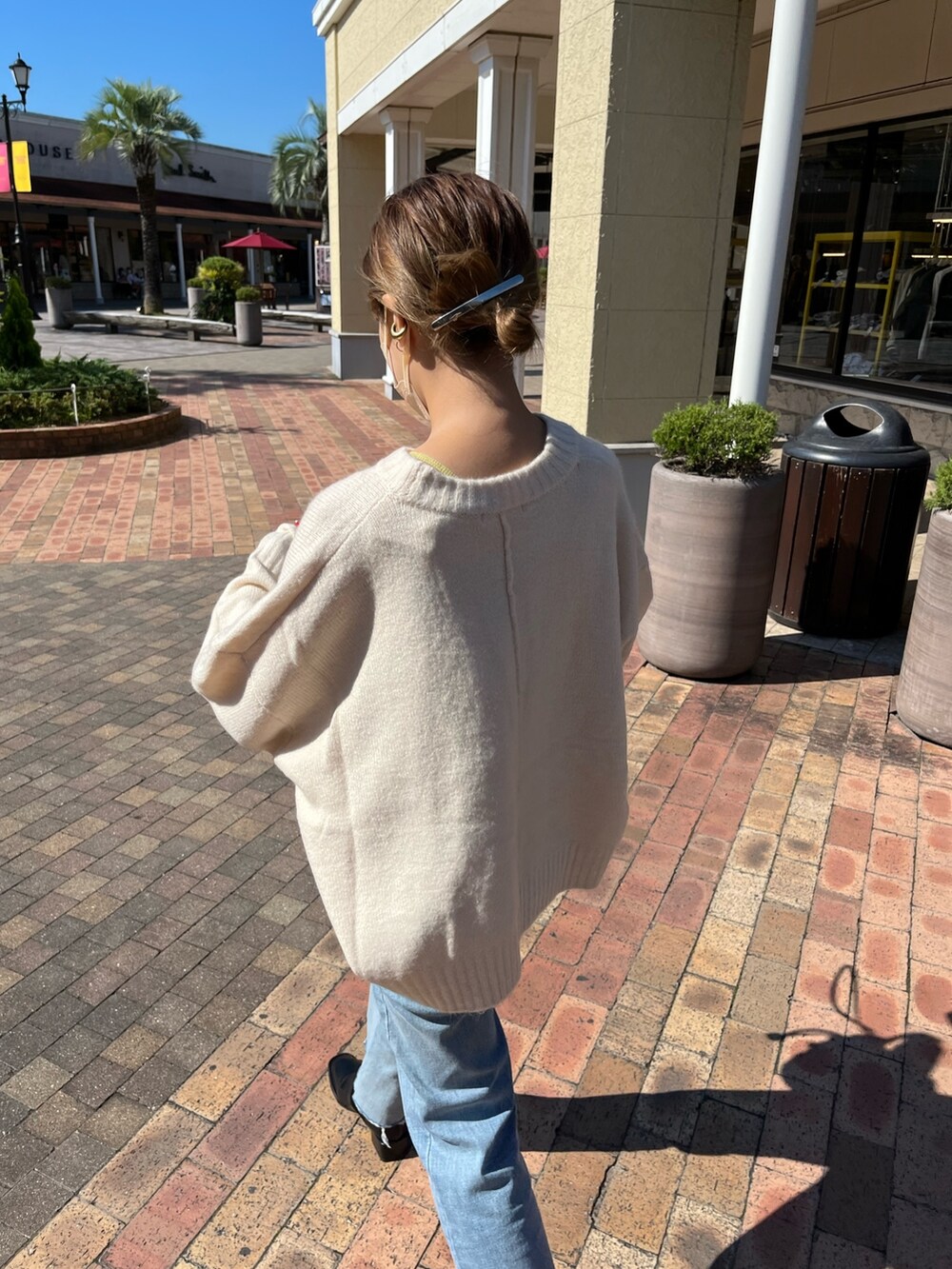 ホワイト系のニット/セーター、ブルー系のデニムパンツ、レッド系のショルダーバッグを着用したレディースの秋コーディネートの3枚目の写真