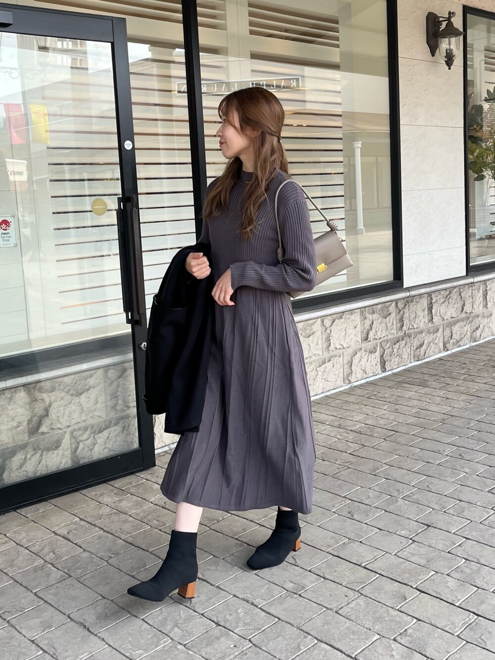 グレー系のワンピース、ブラック系のブーツを着用したレディースの冬コーディネートの2枚目の写真