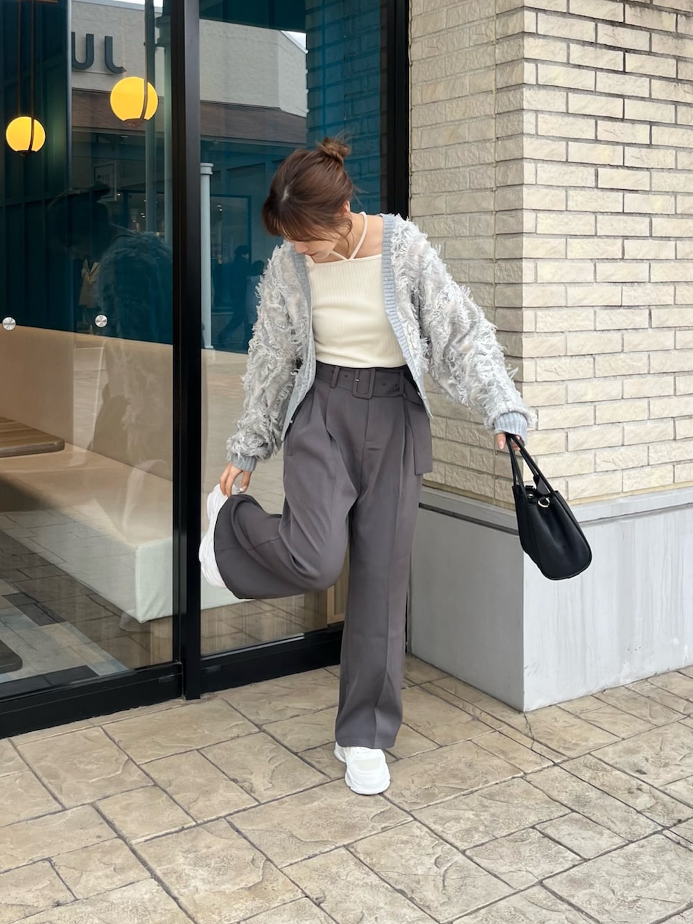 ホワイト系のTシャツ/カットソー、グレー系のカーディガン/ボレロ、グレー系のスラックスを着用したレディースの冬コーディネートの3枚目の写真