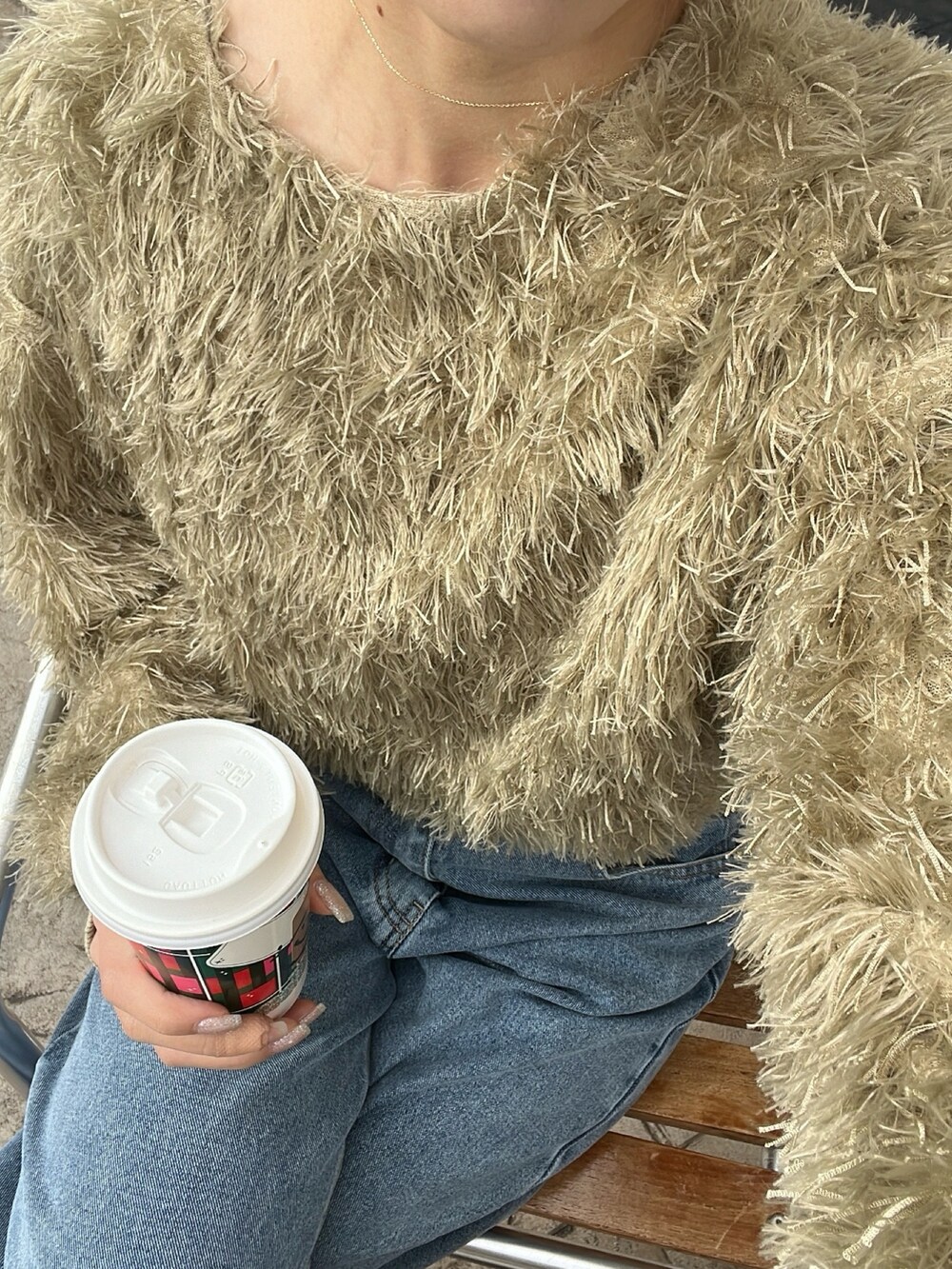 グリーン系のTシャツ/カットソー、ブルー系のデニムパンツ、ブラック系のブーツを着用したレディースの冬コーディネートの3枚目の写真