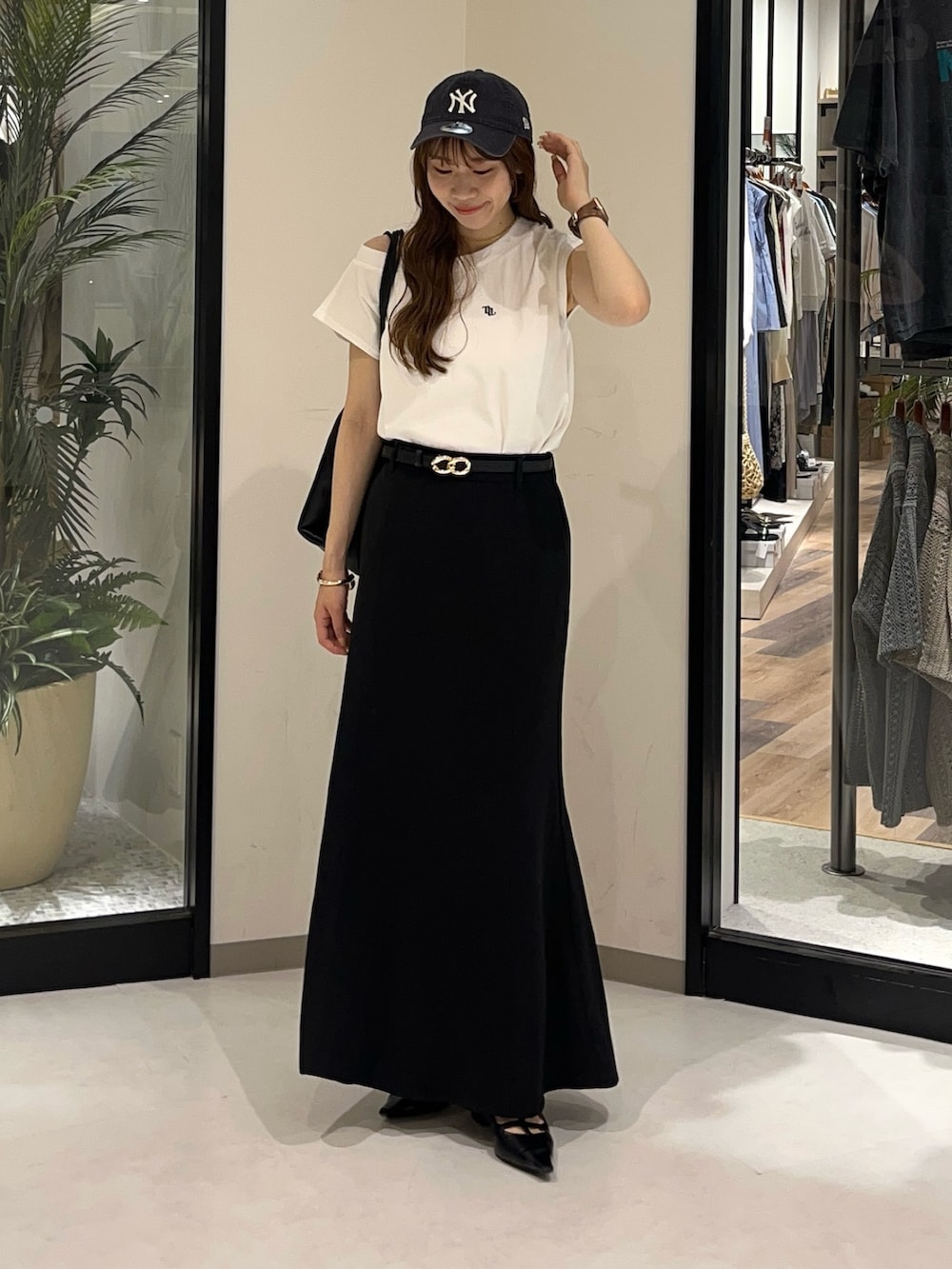 ホワイト系のTシャツ/カットソー、ブラック系のスカート、ブラック系のバックパック/リュックを着用したレディースの夏コーディネートの3枚目の写真