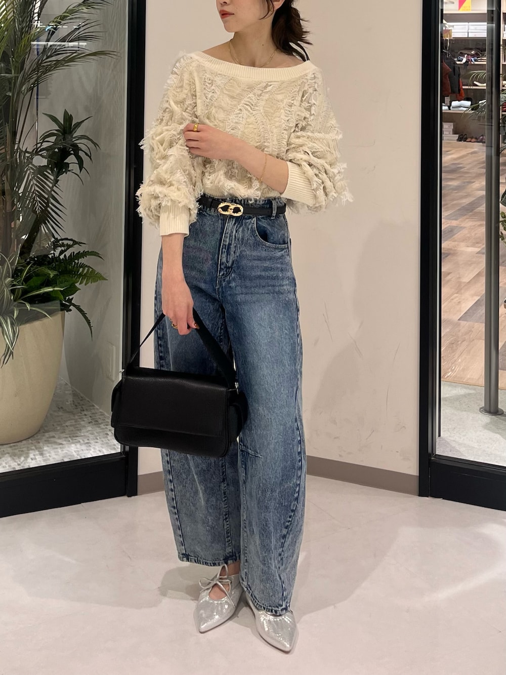 ホワイト系のニット/セーター、ブルー系のその他パンツ、ブラック系のボストンバッグを着用したレディースの春コーディネートの2枚目の写真