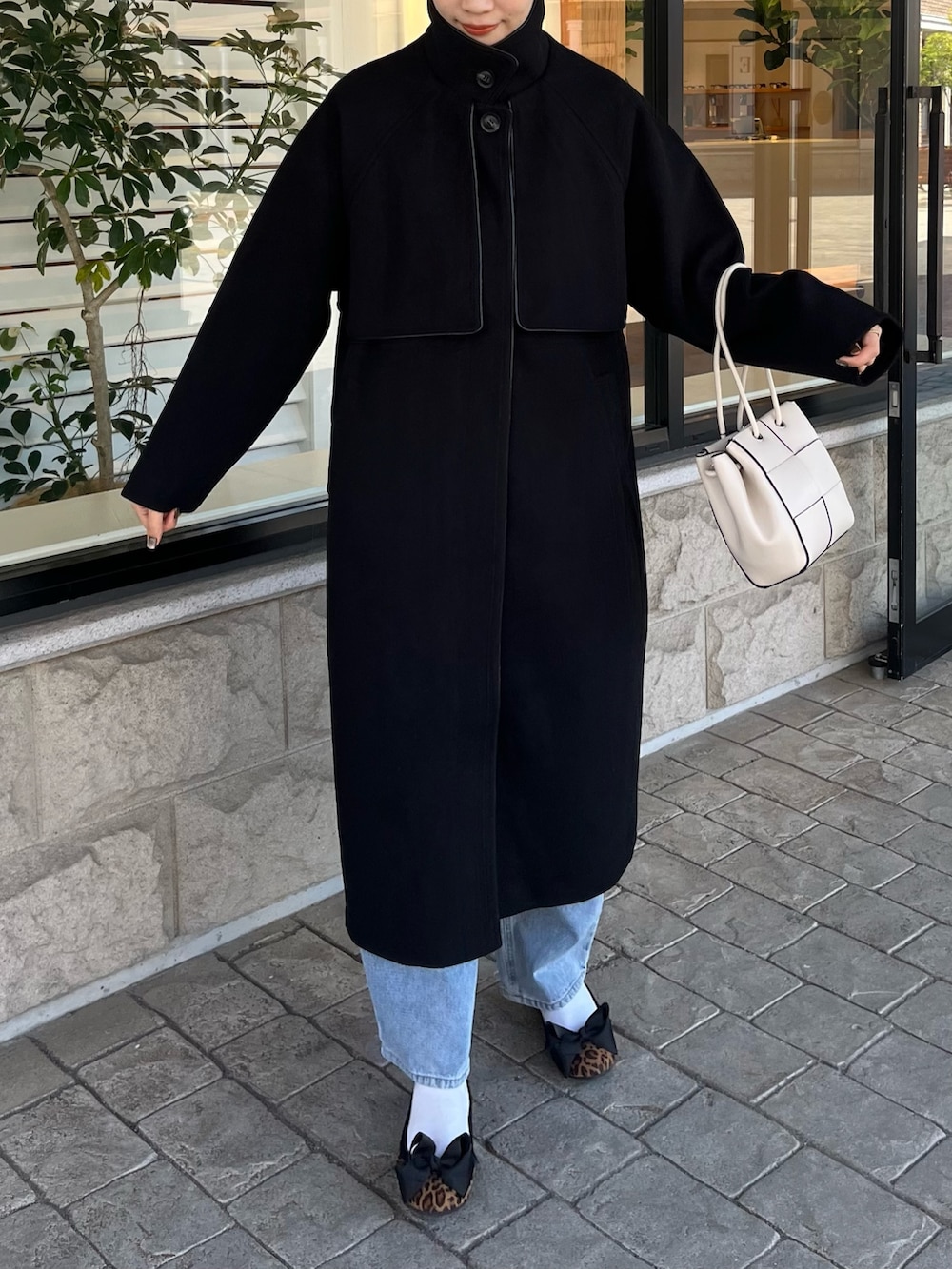 ホワイト系のニット/セーター、ブルー系のデニムパンツ、ホワイト系のショルダーバッグを着用したレディースの秋コーディネートの7枚目の写真