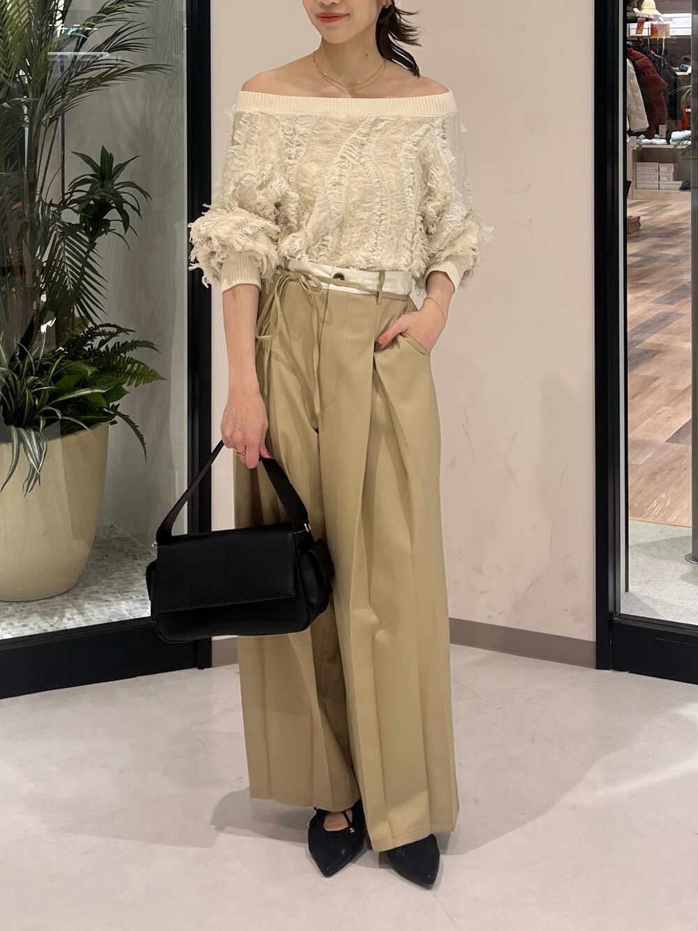 ホワイト系のニット/セーター、ベージュ系のその他パンツ、ブラック系のボストンバッグを着用したレディースの春コーディネートの3枚目の写真