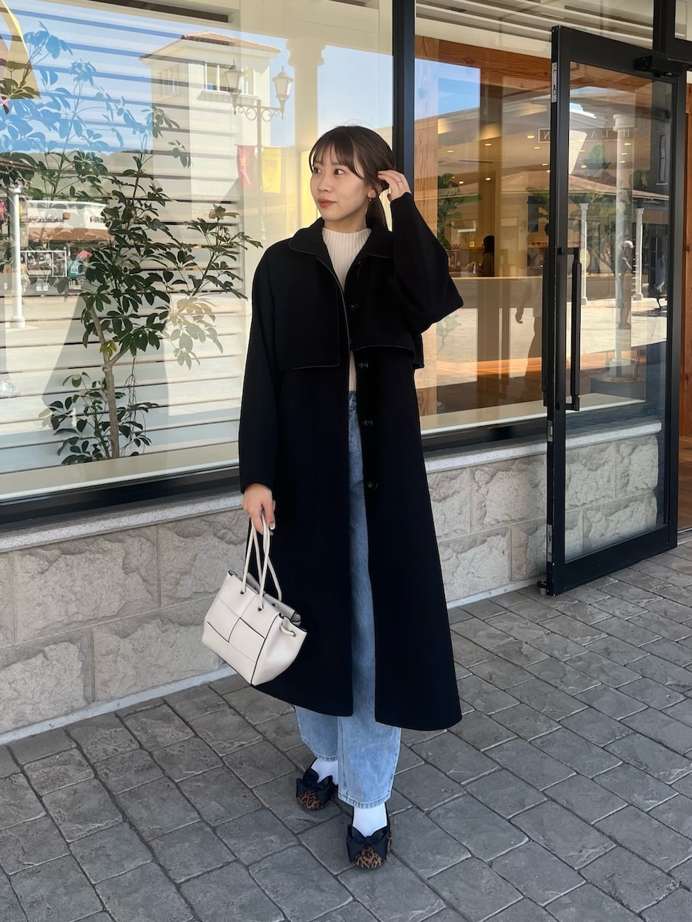 ホワイト系のニット/セーター、ブルー系のデニムパンツ、ホワイト系のショルダーバッグを着用したレディースの秋コーディネートの8枚目の写真