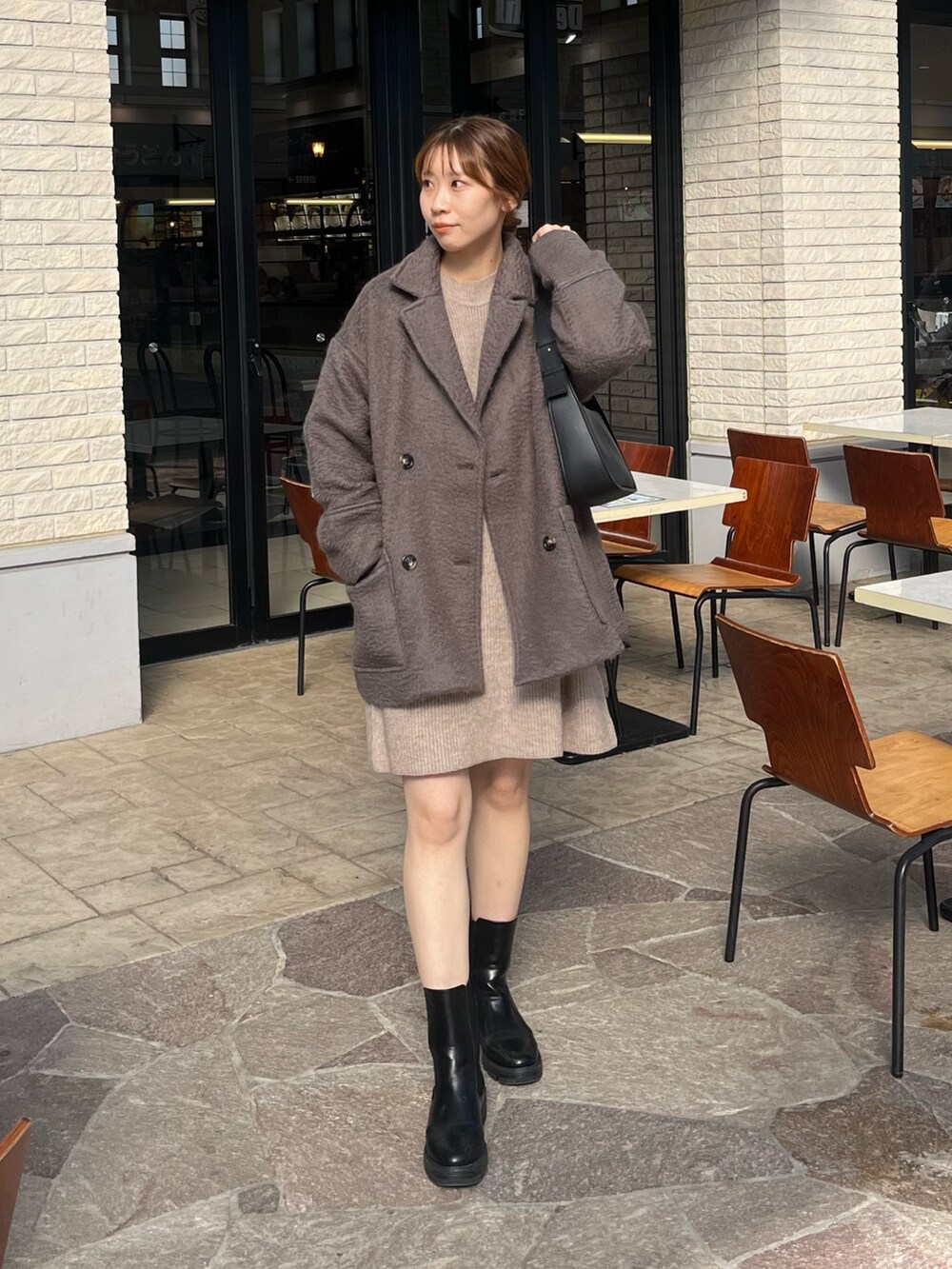 ベージュ系のワンピース、ブラック系のブーツ、グレー系のピーコートを着用したレディースの秋コーディネートの2枚目の写真