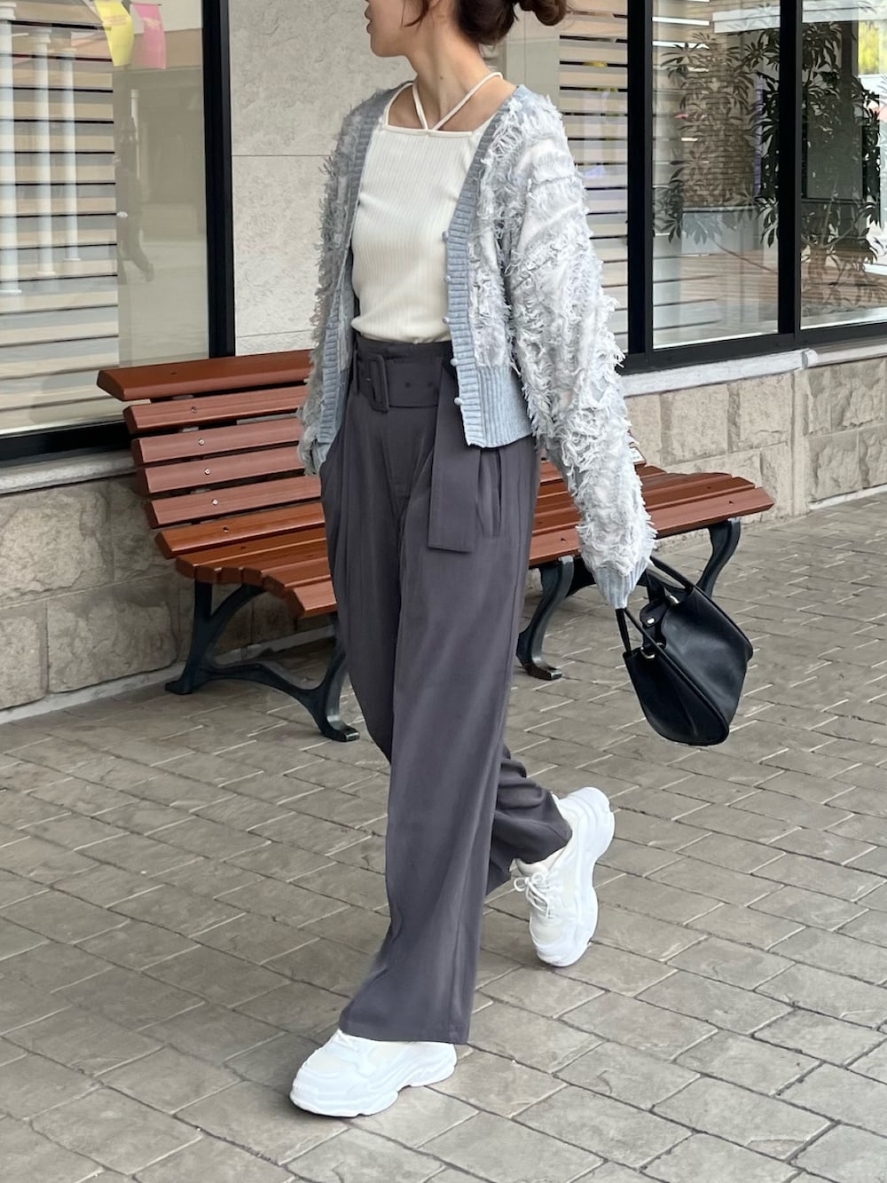 ホワイト系のTシャツ/カットソー、グレー系のカーディガン/ボレロ、グレー系のスラックスを着用したレディースの冬コーディネートの5枚目の写真