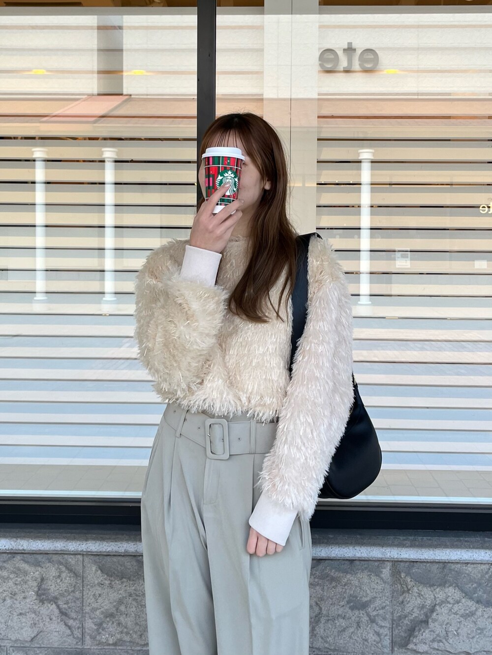 ベージュ系のTシャツ/カットソー、ベージュ系のスラックス、ブラック系のブーツを着用したレディースの冬コーディネートの2枚目の写真