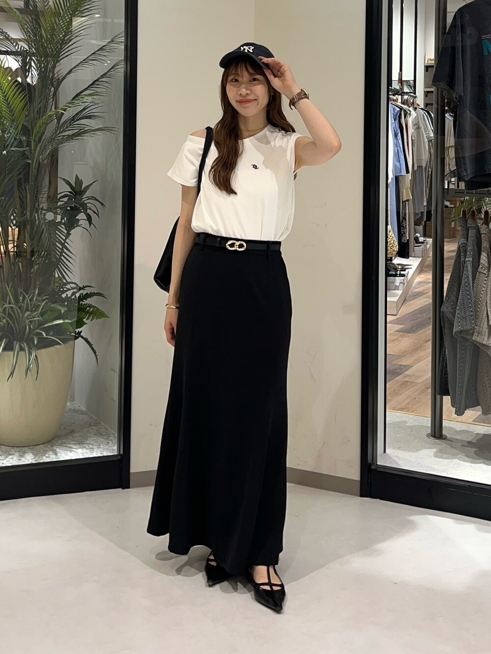 ホワイト系のTシャツ/カットソー、ブラック系のスカート、ブラック系のバックパック/リュックを着用したレディースの夏コーディネートの2枚目の写真