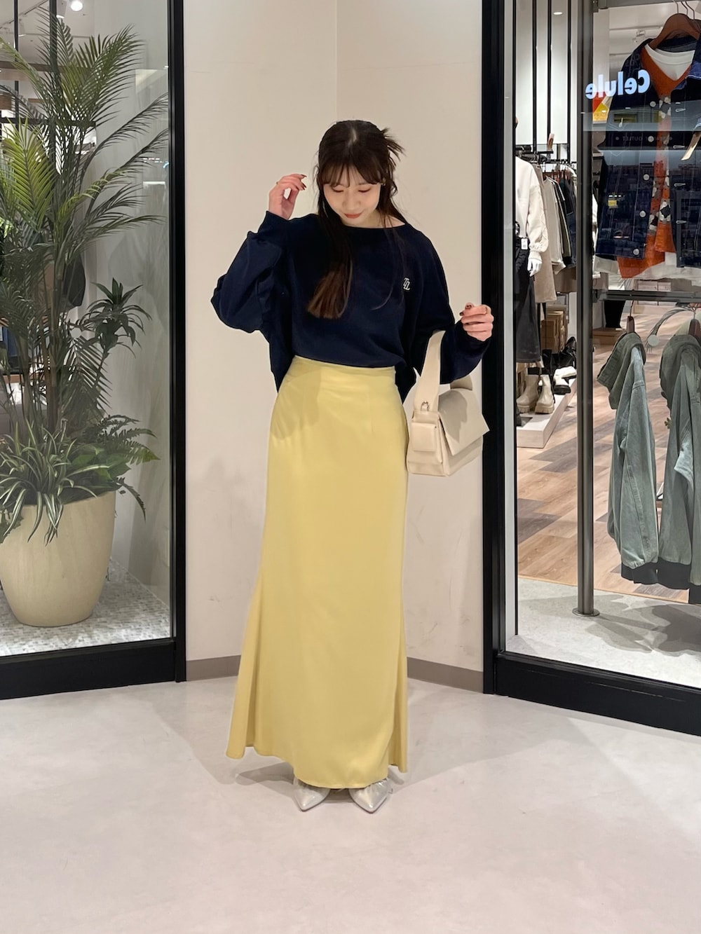 ブルー系のTシャツ/カットソー、イエロー系のスカート、ホワイト系のボストンバッグを着用したレディースの春コーディネートの2枚目の写真