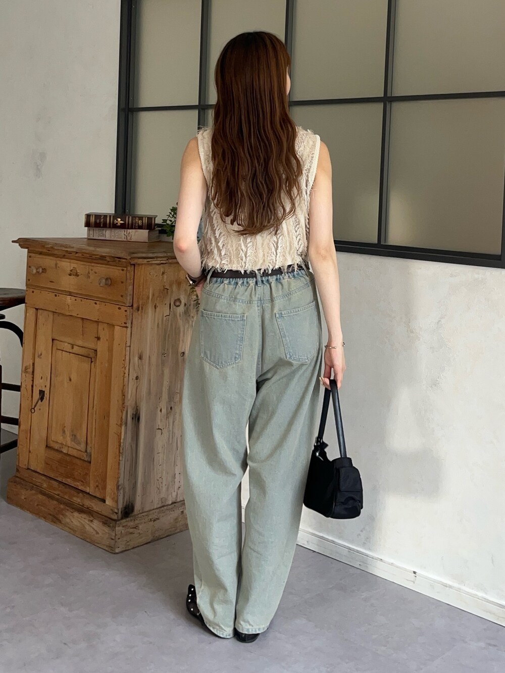 ホワイト系のニット/セーター、ブルー系のデニムパンツ、ブラック系のサンダルを着用したレディースの夏コーディネートの3枚目の写真