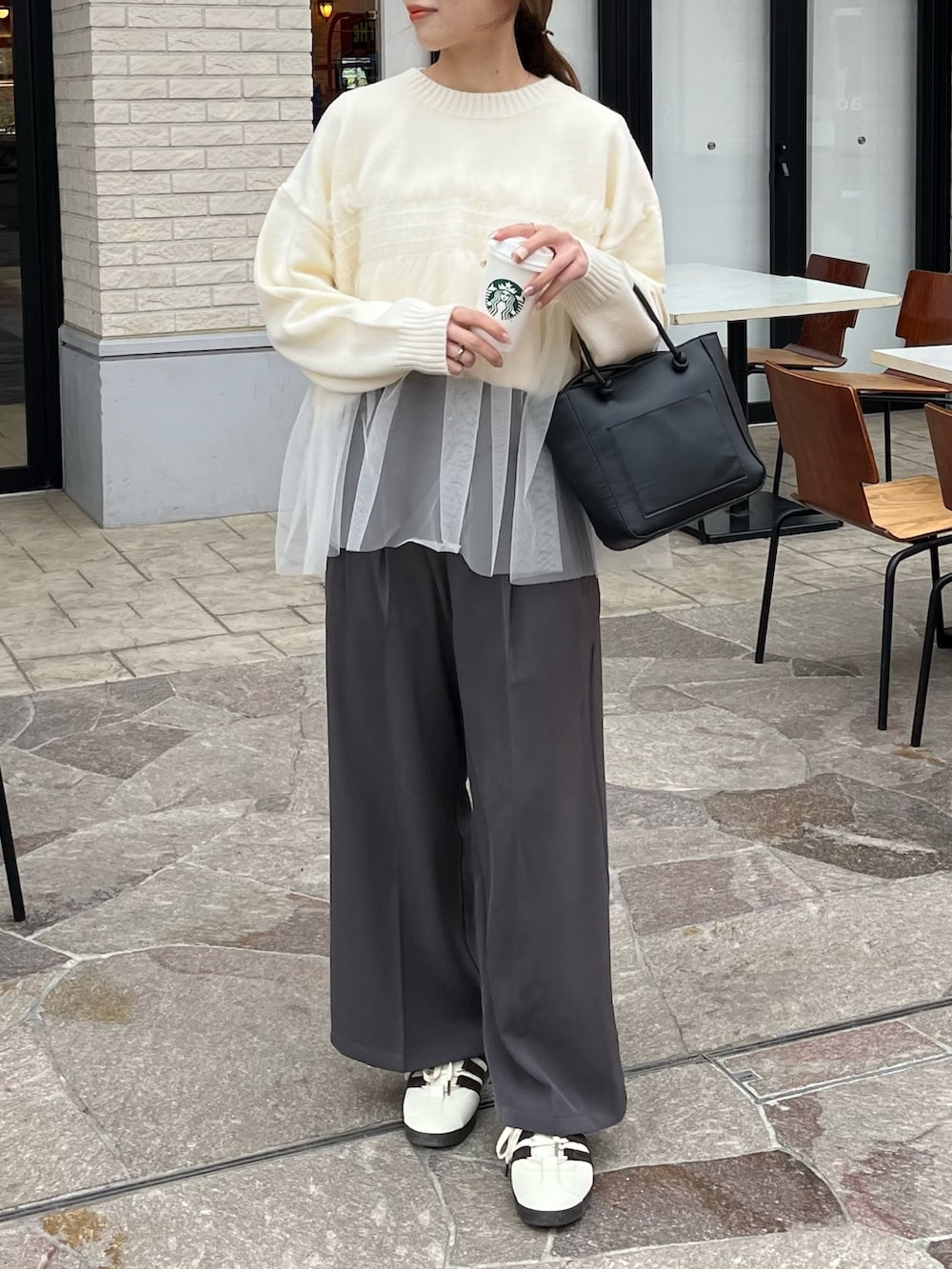 ホワイト系のニット/セーター、グレー系のスラックスを着用したレディースの冬コーディネートの6枚目の写真