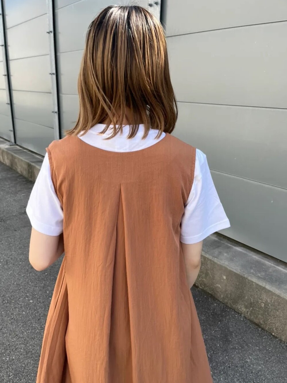 オレンジ系のワンピース、ブルー系のデニムパンツを着用したレディースの夏コーディネートの3枚目の写真