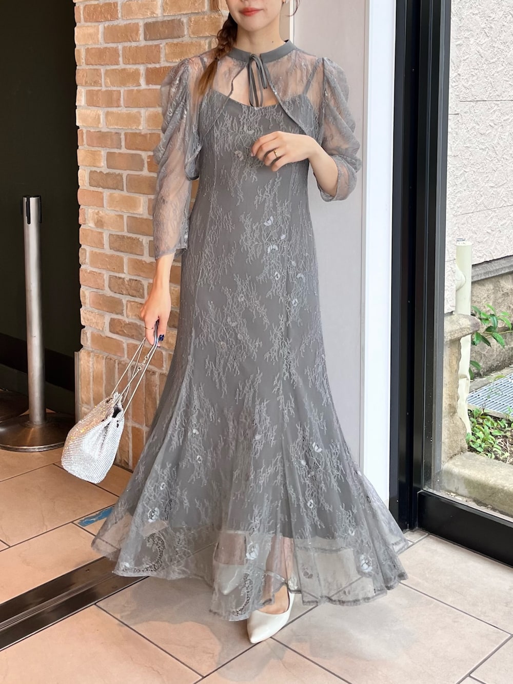 グレー系のドレス、シルバー系のハンドバッグを着用したレディースの秋コーディネートの2枚目の写真