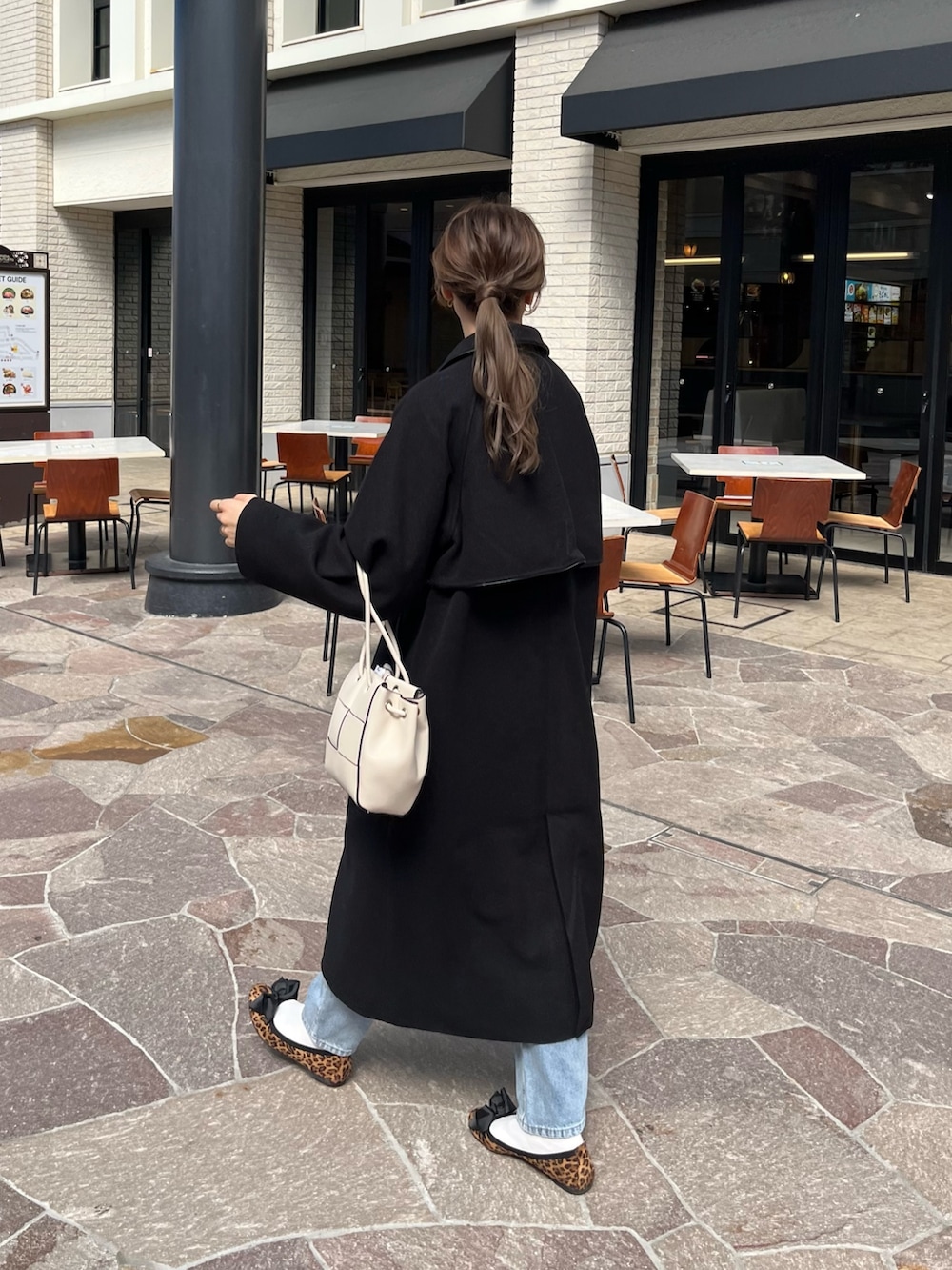 ホワイト系のニット/セーター、ブルー系のデニムパンツ、ホワイト系のショルダーバッグを着用したレディースの秋コーディネートの3枚目の写真