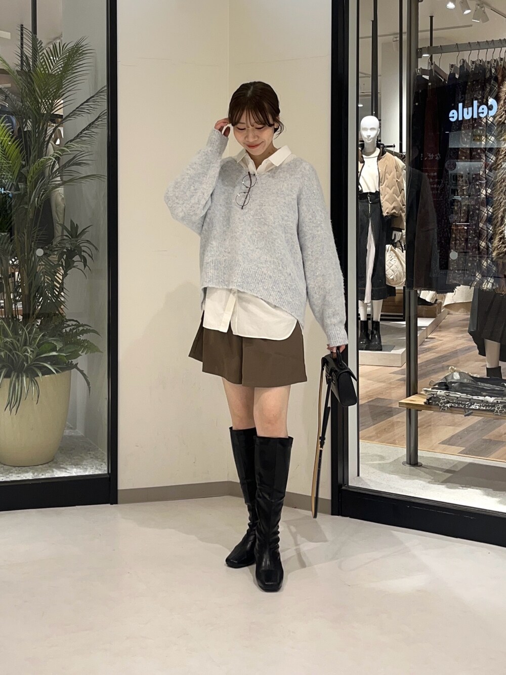 ブルー系のニット/セーター、ブラウン系のその他パンツ、ブラック系のブーツを着用したレディースの冬コーディネートの2枚目の写真