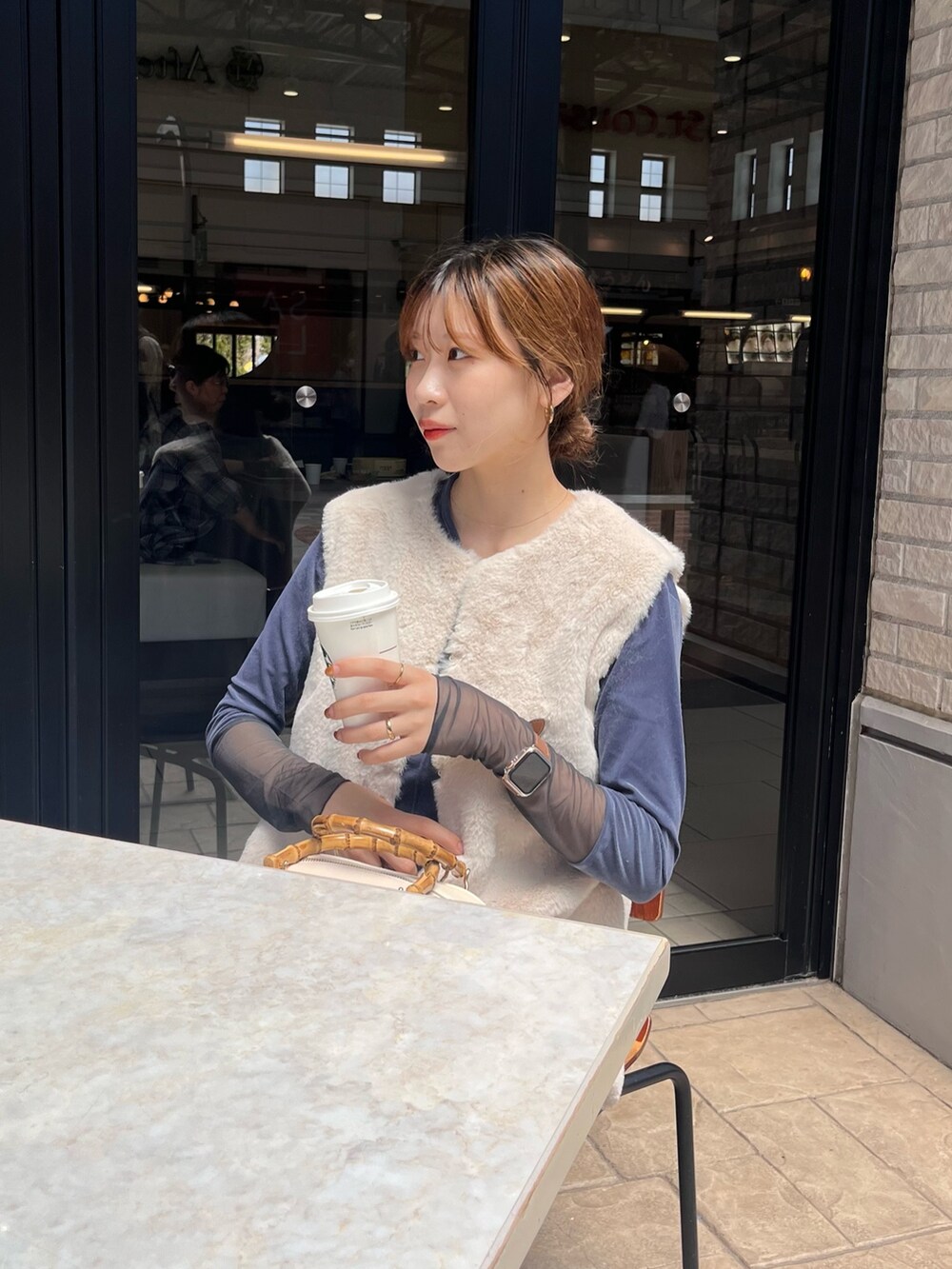 ホワイト系のベスト、ブルー系のTシャツ/カットソー、ブルー系のデニムパンツを着用したレディースの秋コーディネートの2枚目の写真