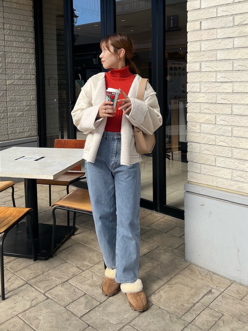 オレンジ系のニット/セーター、ホワイト系のブルゾン、ベージュ系のショルダーバッグを着用したレディースの秋コーディネートの6枚目の写真