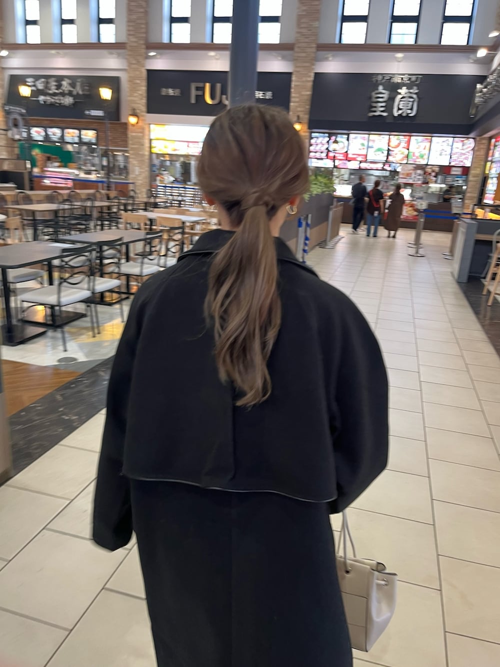 ホワイト系のニット/セーター、ブルー系のデニムパンツ、ホワイト系のショルダーバッグを着用したレディースの秋コーディネートの6枚目の写真