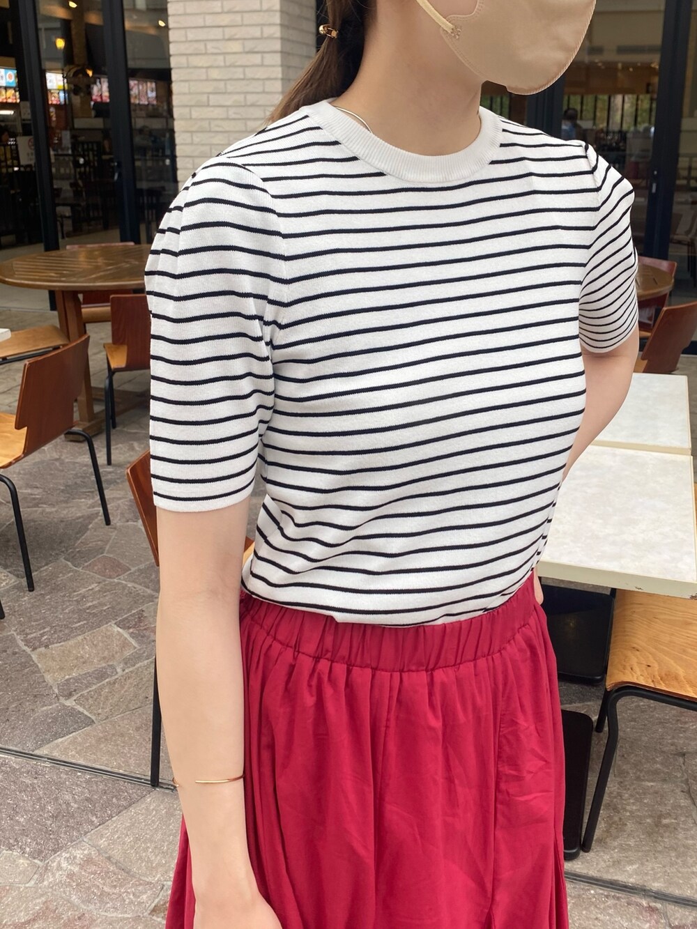 ホワイト系のニット/セーター、ピンク系のスカート、ブラック系のサンダルを着用したレディースの夏コーディネートの2枚目の写真