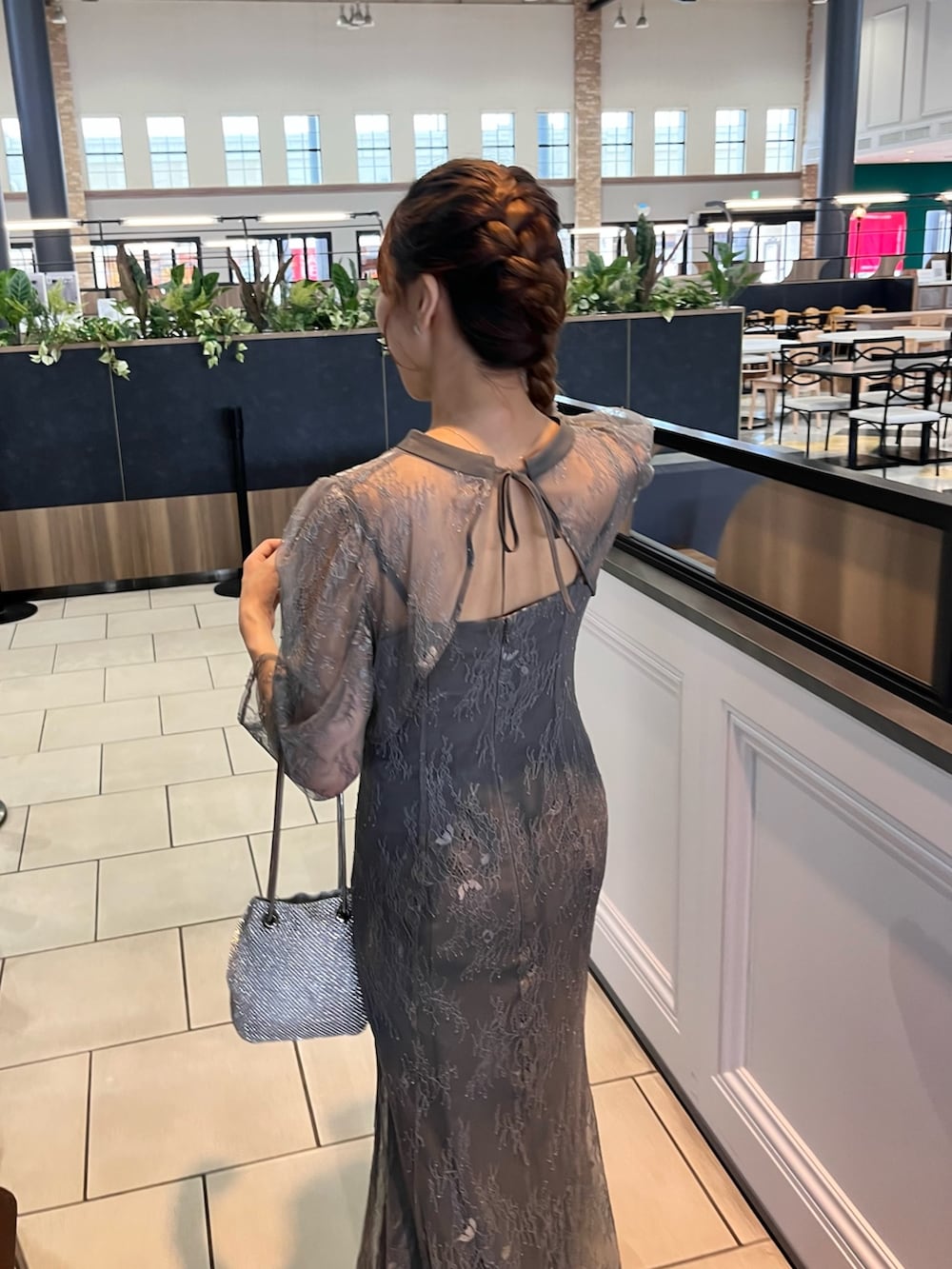 グレー系のドレス、シルバー系のハンドバッグを着用したレディースの秋コーディネートの3枚目の写真