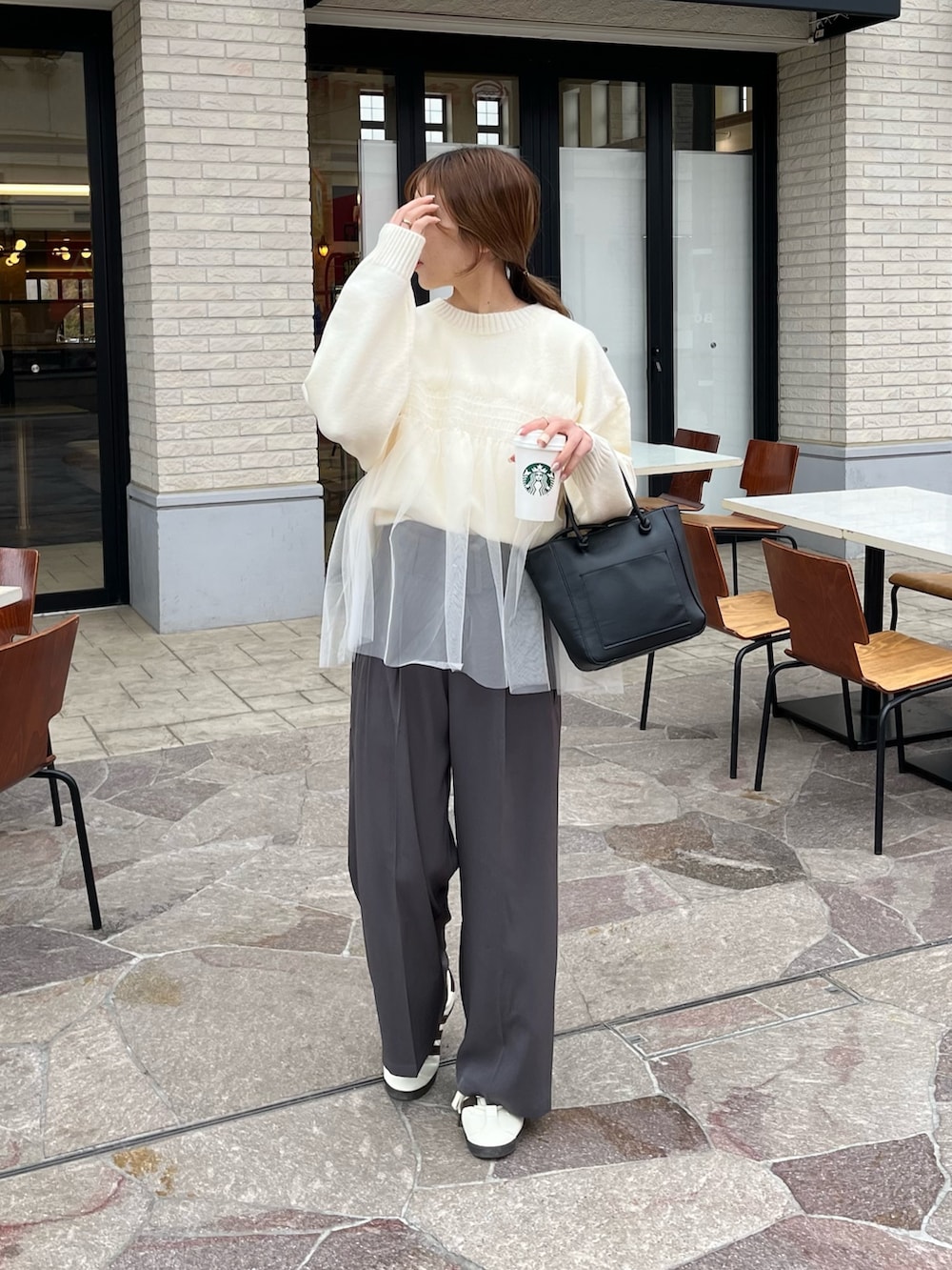 ホワイト系のニット/セーター、グレー系のスラックスを着用したレディースの冬コーディネートの5枚目の写真
