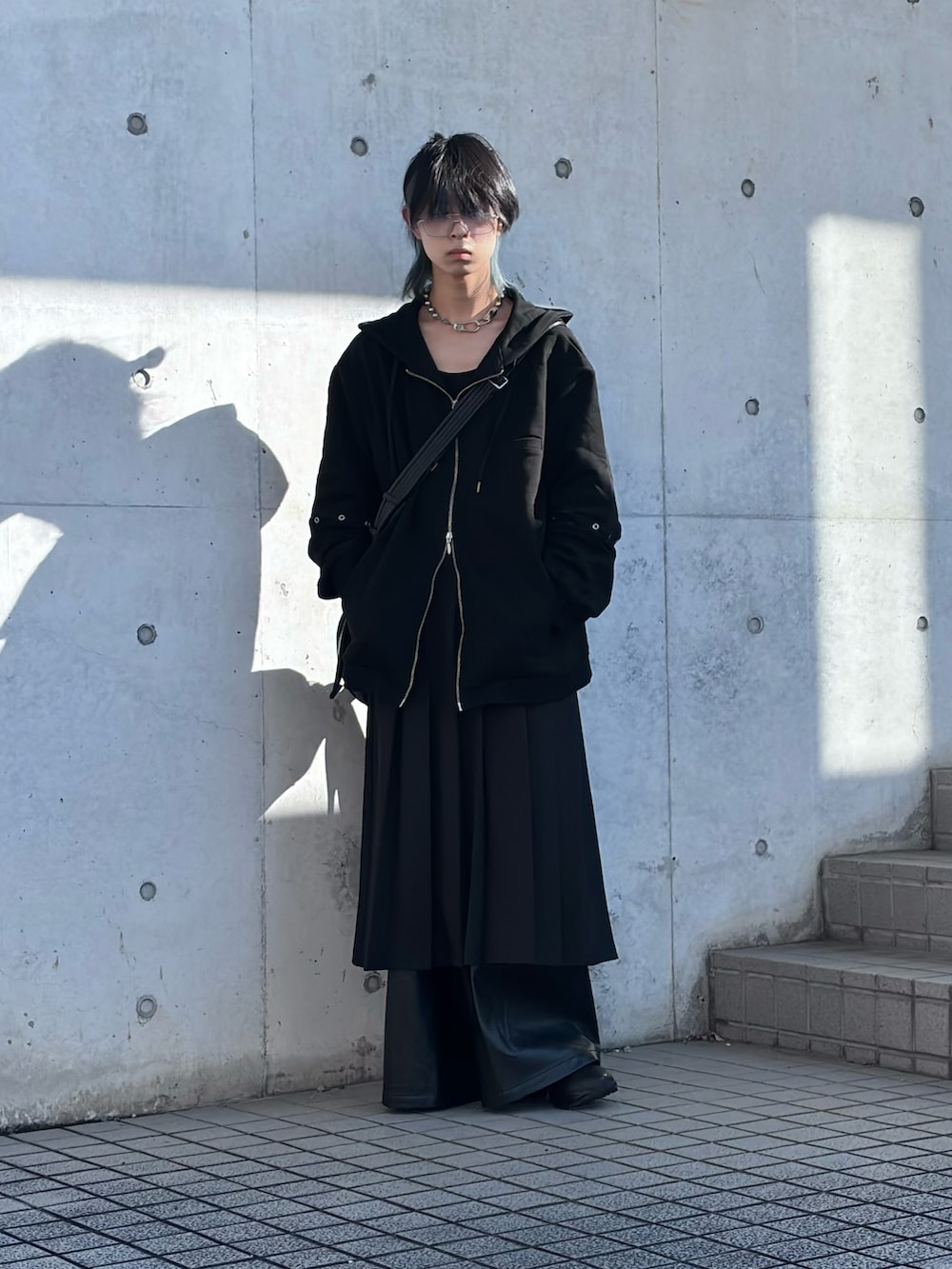 ブラック系のパーカー、ブラック系のショルダーバッグ、ブラック系のスカートを着用したメンズの冬コーディネートの3枚目の写真